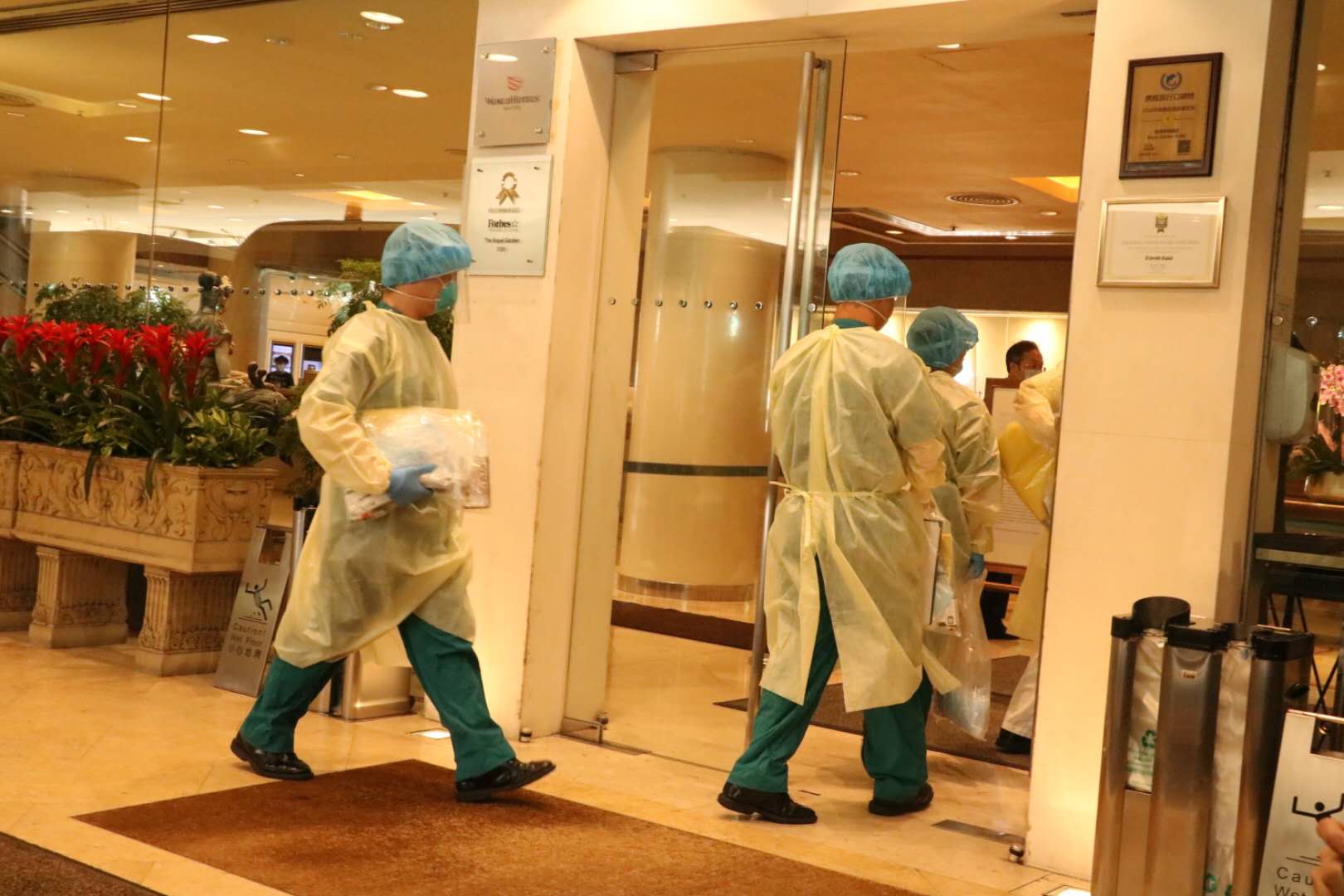 穿上全副保護衣的人員進入帝苑酒店（香港文匯報記者攝）