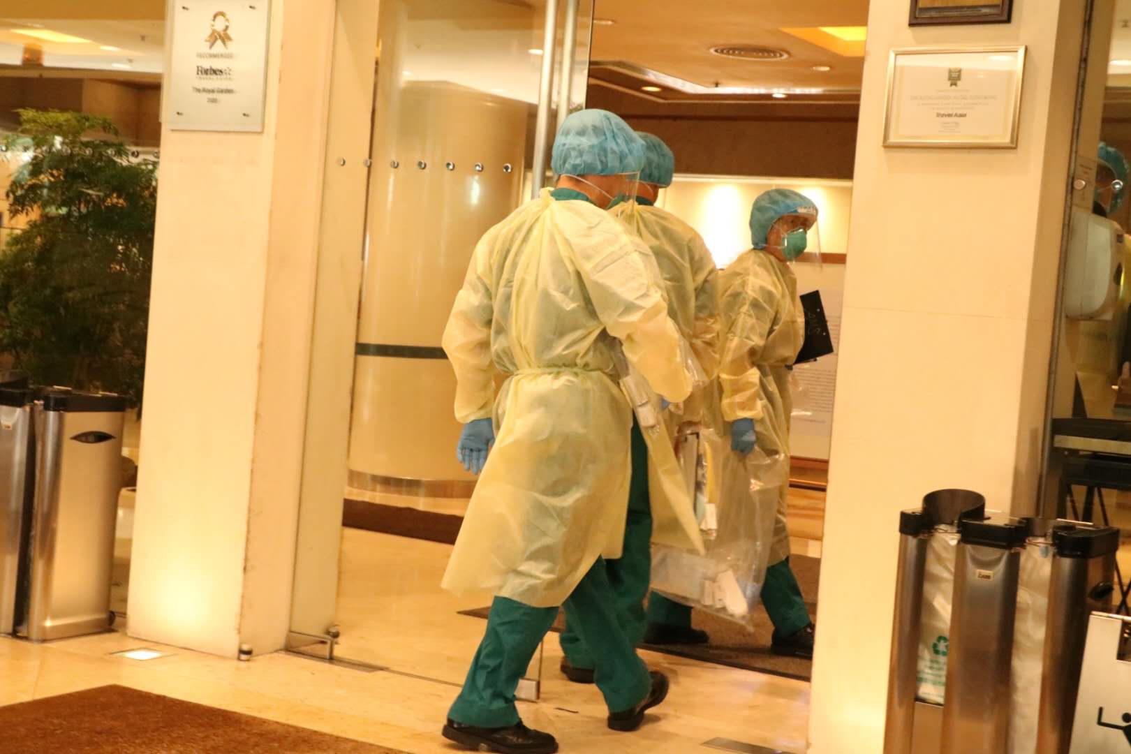 穿上全副保護衣的人員進入帝苑酒店（香港文匯報記者攝）