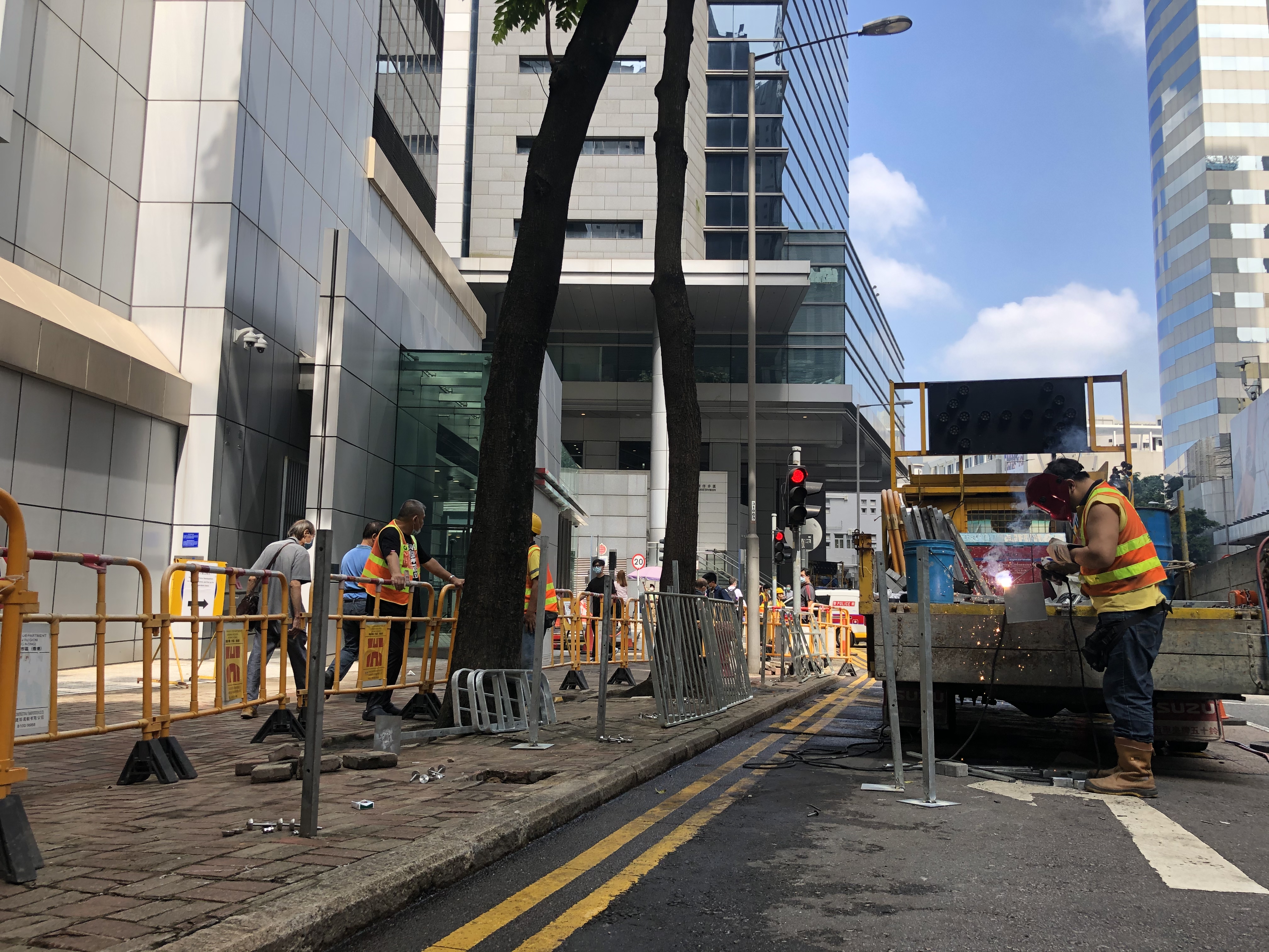 香港國安法生效以來，暴徒受到震懾，黑暴行為漸漸降溫。昨晚，位於灣仔軍器廠街的警察總部外水馬被撤走。今日上午，記者到達現場，發現警總外已看不到水馬，惟擺了一年的水馬，令地上留下痕跡，工人正在現場施工。據悉，本港多個政府部門及中央駐港機構，在去年反修例示威時，由7月開始架設大型水馬，而除了警察總部，多間警署外亦都放置有水馬。（大公報突發組攝）