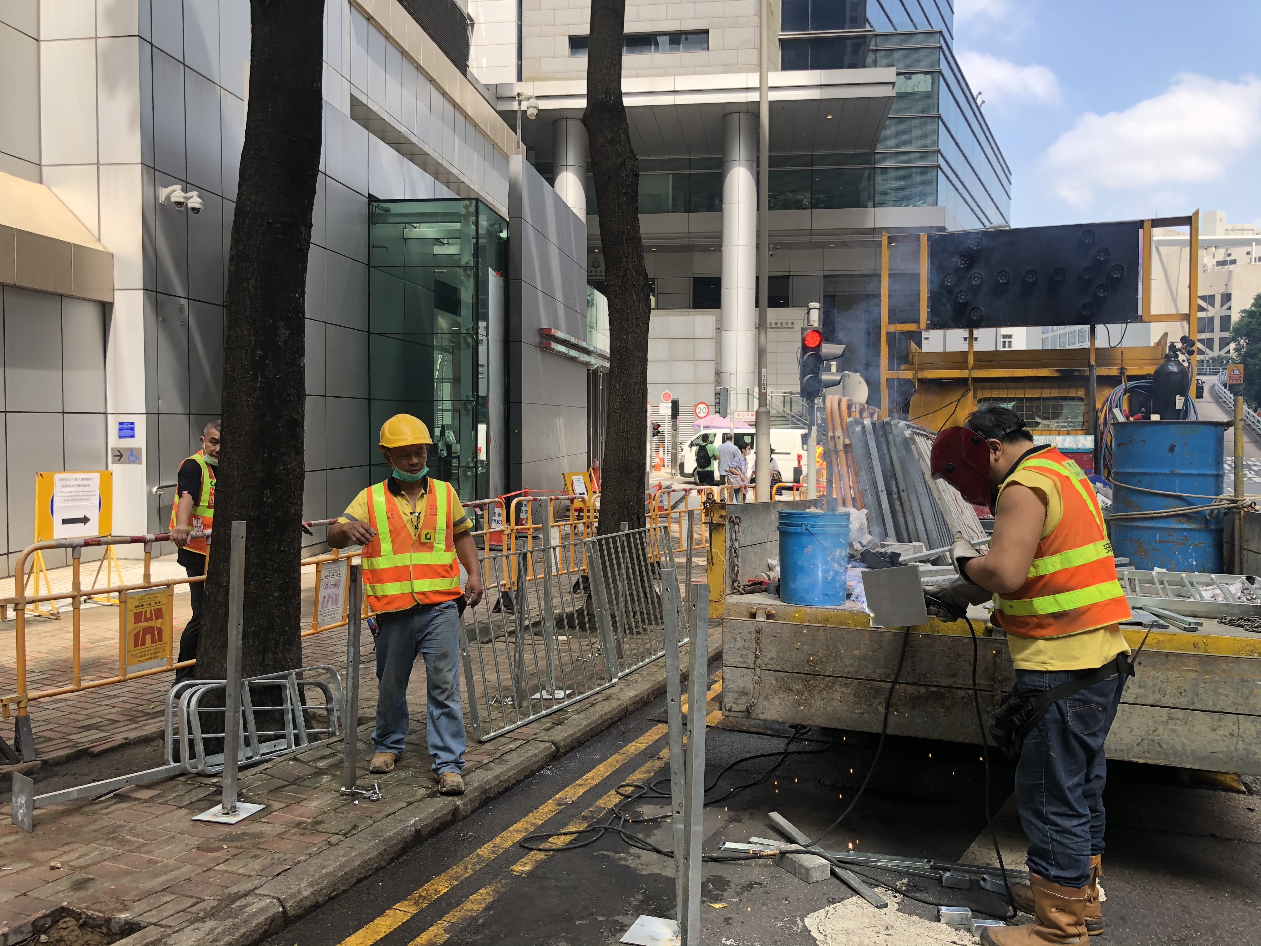 香港國安法生效以來，暴徒受到震懾，黑暴行為漸漸降溫。昨晚，位於灣仔軍器廠街的警察總部外水馬被撤走。今日上午，記者到達現場，發現警總外已看不到水馬，惟擺了一年的水馬，令地上留下痕跡，工人正在現場施工。據悉，本港多個政府部門及中央駐港機構，在去年反修例示威時，由7月開始架設大型水馬，而除了警察總部，多間警署外亦都放置有水馬。（大公報突發組攝）