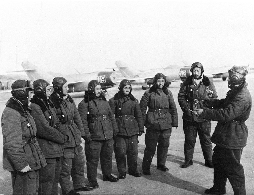 志願軍空軍戰鬥英雄王海（右一）向飛行員講解戰術（來源：解放軍畫報）
