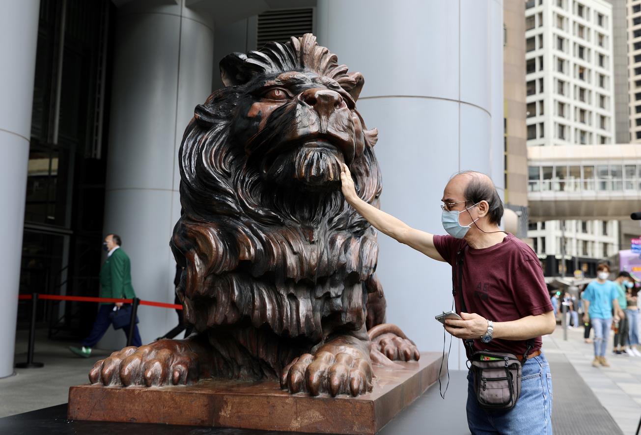 10月22日上午，滙豐銅獅重開，工作人員為獅子揭布並點睛。一些市民和滙豐員工特地前來合影留念，現場可見銅獅身上上大部分污漬被清理，只留有此前被燒過的痕跡。
市民林先生表示，見到銅獅重開感到高興，形容銅獅子是屬於香港人的集體回憶，他希望滙豐能夠將總部搬回香港，早日重振旗鼓。圖為：一位市民撫摸銅獅子（大公文匯全媒體記者 李斯哲 攝）