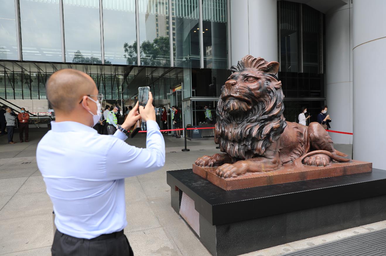 10月22日上午，滙豐銅獅重開，工作人員為獅子揭布並點睛。一些市民和滙豐員工特地前來合影留念，現場可見銅獅身上上大部分污漬被清理，只留有此前被燒過的痕跡。
市民林先生表示，見到銅獅重開感到高興，形容銅獅子是屬於香港人的集體回憶，他希望滙豐能夠將總部搬回香港，早日重振旗鼓。圖為：市民在銅獅子前影相留念（大公文匯全媒體記者 李斯哲 攝）