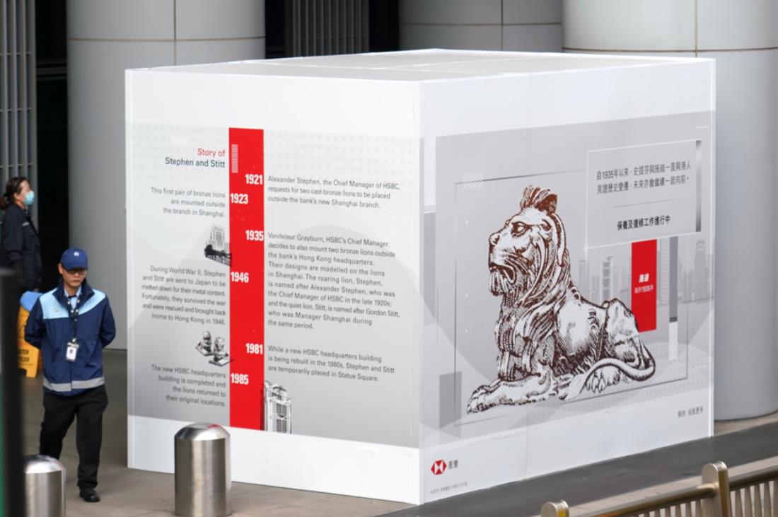 香港匯豐銀行總行大樓前一對銅獅今年元旦遭蒙面黑衣人噴漆和縱火，隨後匯豐啟動修復工程。圖為：1月10日，圍擋銅獅的白板上張貼了銅獅的畫像和介紹銅獅來歷的文字，市民可以通過圖片和文字了解銅獅前世今生(香港中通社)