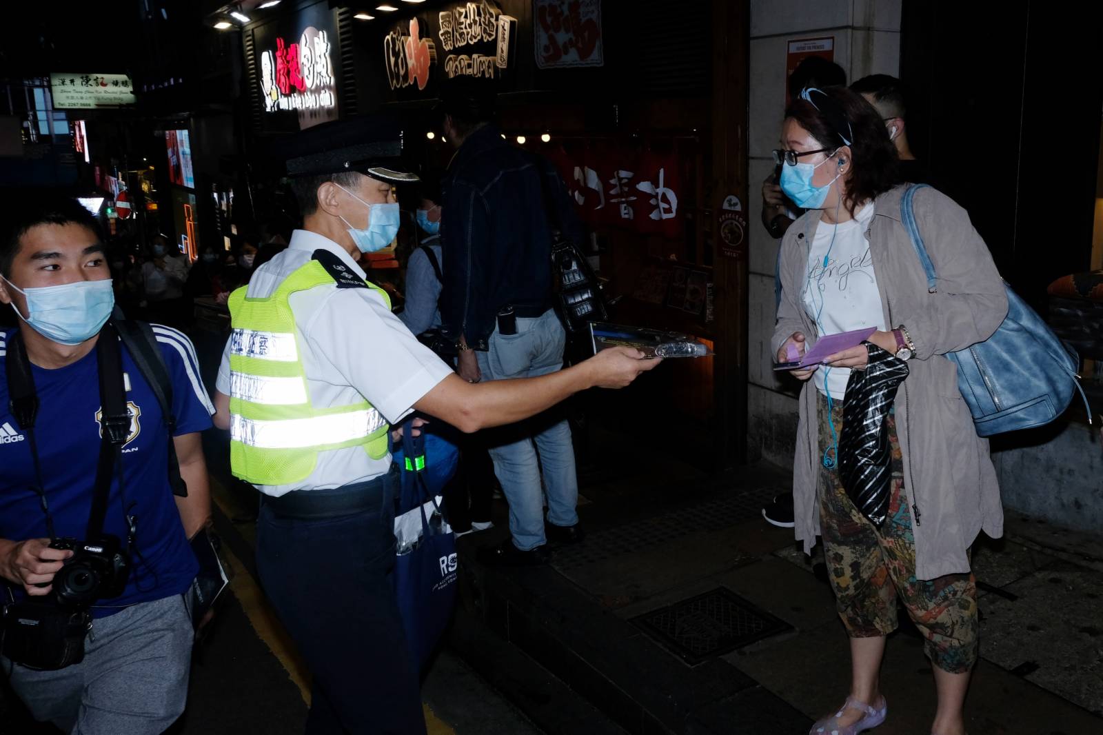 香港警方在現場加強執法，向市民分發相關資料，籲市民遵守防疫規例(大公文匯全媒體記者 麥鈞傑攝)