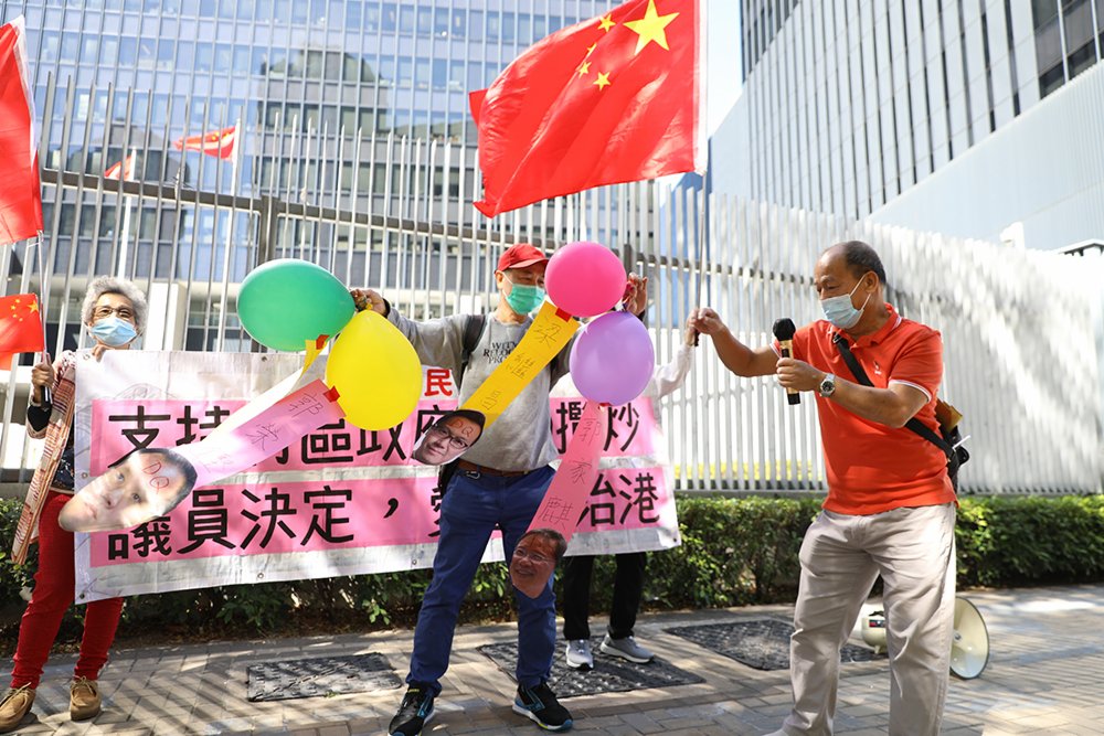 多個市民團體前往政府總部，支持人大和特區政府DQ攬炒派議員。有市民攜帶香檳慶祝，亦有市民戳破貼有4位攬炒派議員頭像的氣球，寓意破除立法會4害。大公文匯全媒體 攝