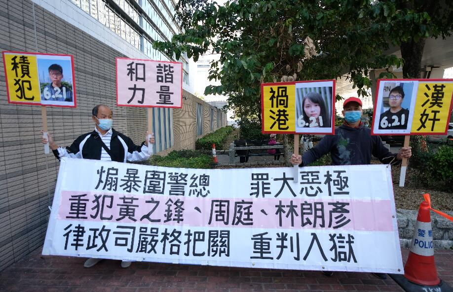 前香港眾志秘書長黃之鋒、前成員周庭及前主席林朗彥被指於去年6·21參與包圍警總，被控煽惑、組織及參與未經批准集結等罪名。三人早前先後認罪，裁判官王詩麗將於今日下午判刑。三人今早已分別由囚車押往法庭。圖為市民舉牌斥黃之鋒等三人「漢奸」禍港，促重判三人。(大公文匯全媒體 麥鈞傑 攝)