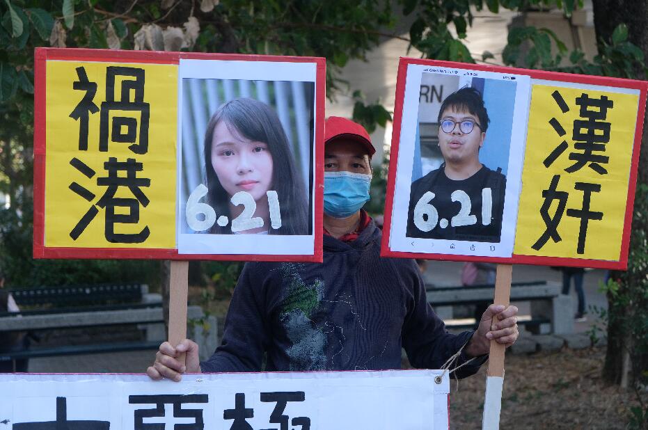 前香港眾志秘書長黃之鋒、前成員周庭及前主席林朗彥被指於去年6·21參與包圍警總，被控煽惑、組織及參與未經批准集結等罪名。三人早前先後認罪，裁判官王詩麗將於今日下午判刑。三人今早已分別由囚車押往法庭。圖為市民舉牌斥黃之鋒等三人「漢奸」禍港，促重判三人。(大公文匯全媒體 麥鈞傑 攝)