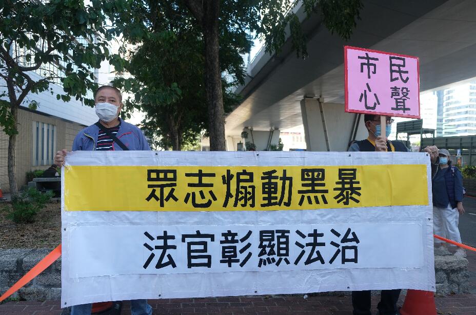 前香港眾志秘書長黃之鋒、前成員周庭及前主席林朗彥被指於去年6·21參與包圍警總，被控煽惑、組織及參與未經批准集結等罪名。三人早前先後認罪，裁判官王詩麗將於今日下午判刑。三人今早已分別由囚車押往法庭。圖為市民舉牌斥黃之鋒等三人「漢奸」禍港，促重判三人。(大公文匯全媒體 麥鈞傑 攝)