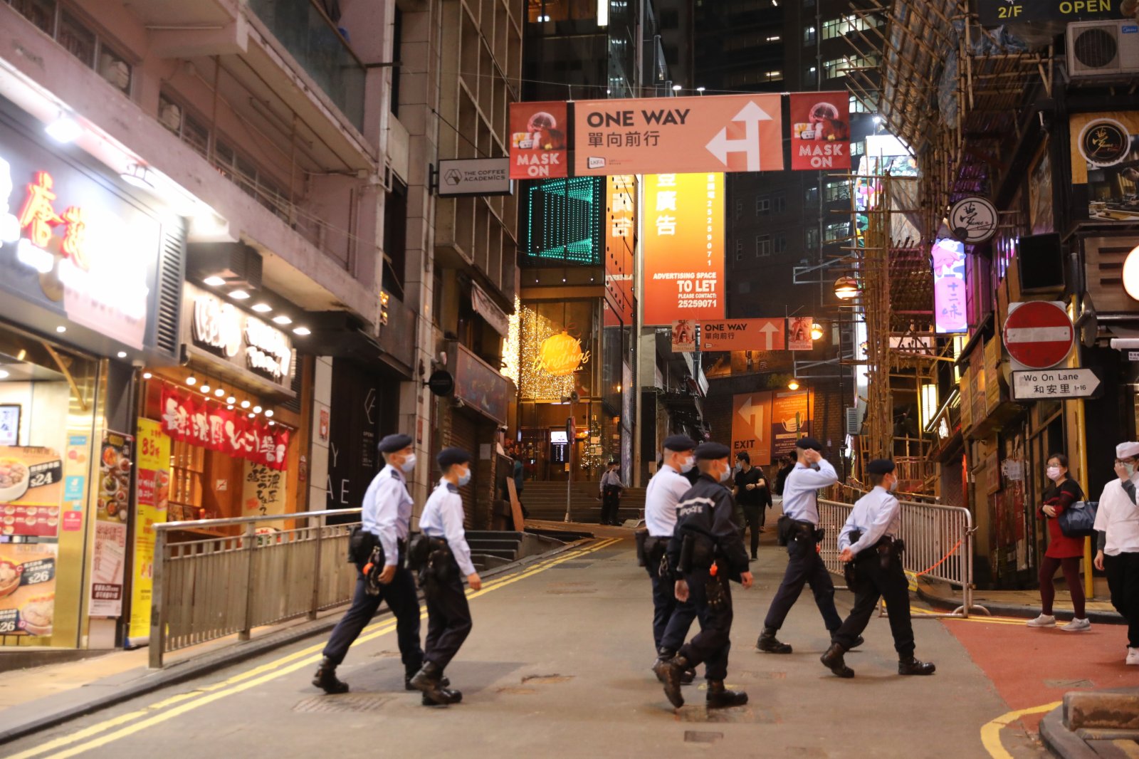 24日，平安夜蘭桂坊街頭「水靜河飛」，酒吧停業，食肆禁堂食，只有少數市民在閒逛。在各個路口均有警察巡邏維持秩序，同時牌照事務署的工作人員到多個商廈巡查，查看有無場所違規營業（大公文匯全媒體記者 李斯哲攝）