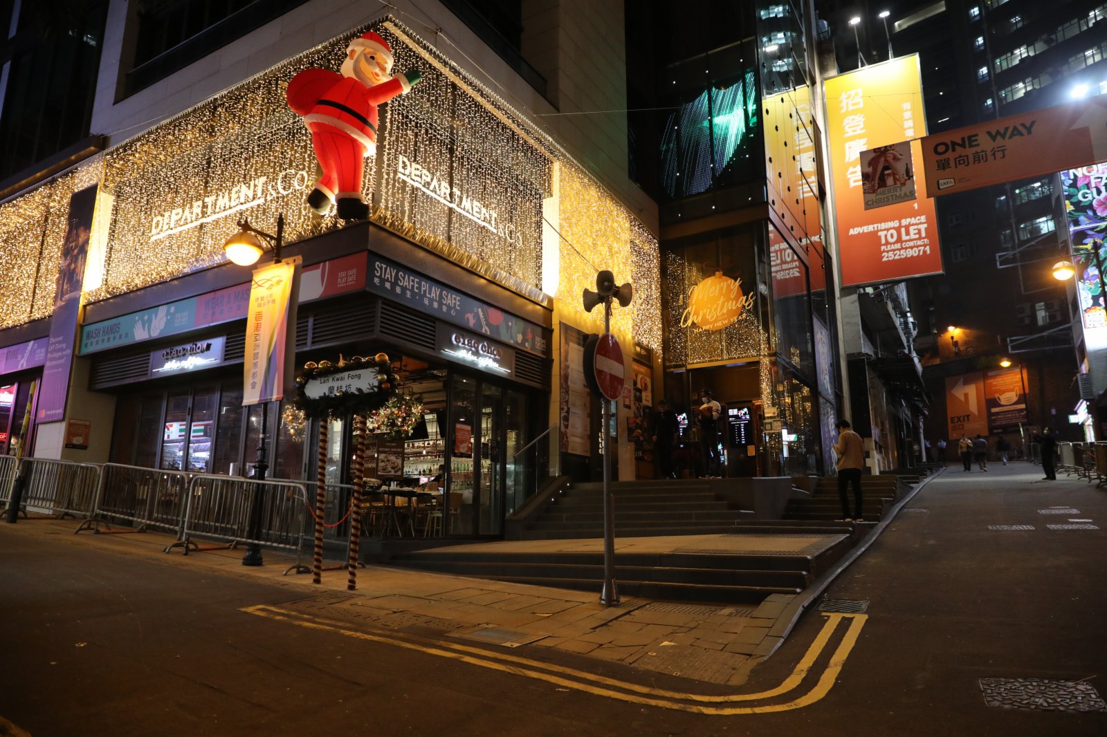 24日，平安夜蘭桂坊街頭「水靜河飛」，酒吧停業，食肆禁堂食，只有少數市民在閒逛。在各個路口均有警察巡邏維持秩序，同時牌照事務署的工作人員到多個商廈巡查，查看有無場所違規營業（大公文匯全媒體記者 李斯哲攝）