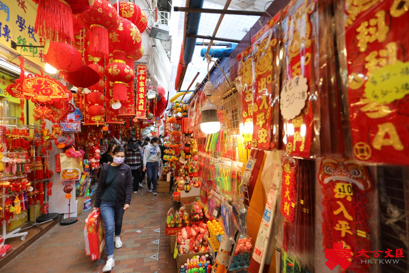 農曆新年將至，有深水埗玩具街之稱的福榮街變身成為「新年街」，不少店鋪在路邊開檔賣牛年賀年公仔、特色揮春，利是封等，大半條街都一片紅噹噹，充滿濃厚節日氣氛。多款賀年飾品唔單止價錢吸引，而且款式仲好齊全，吸引大批市民帶埋一家大細來置辦年貨。（大公文匯全媒體記者 李斯哲攝）