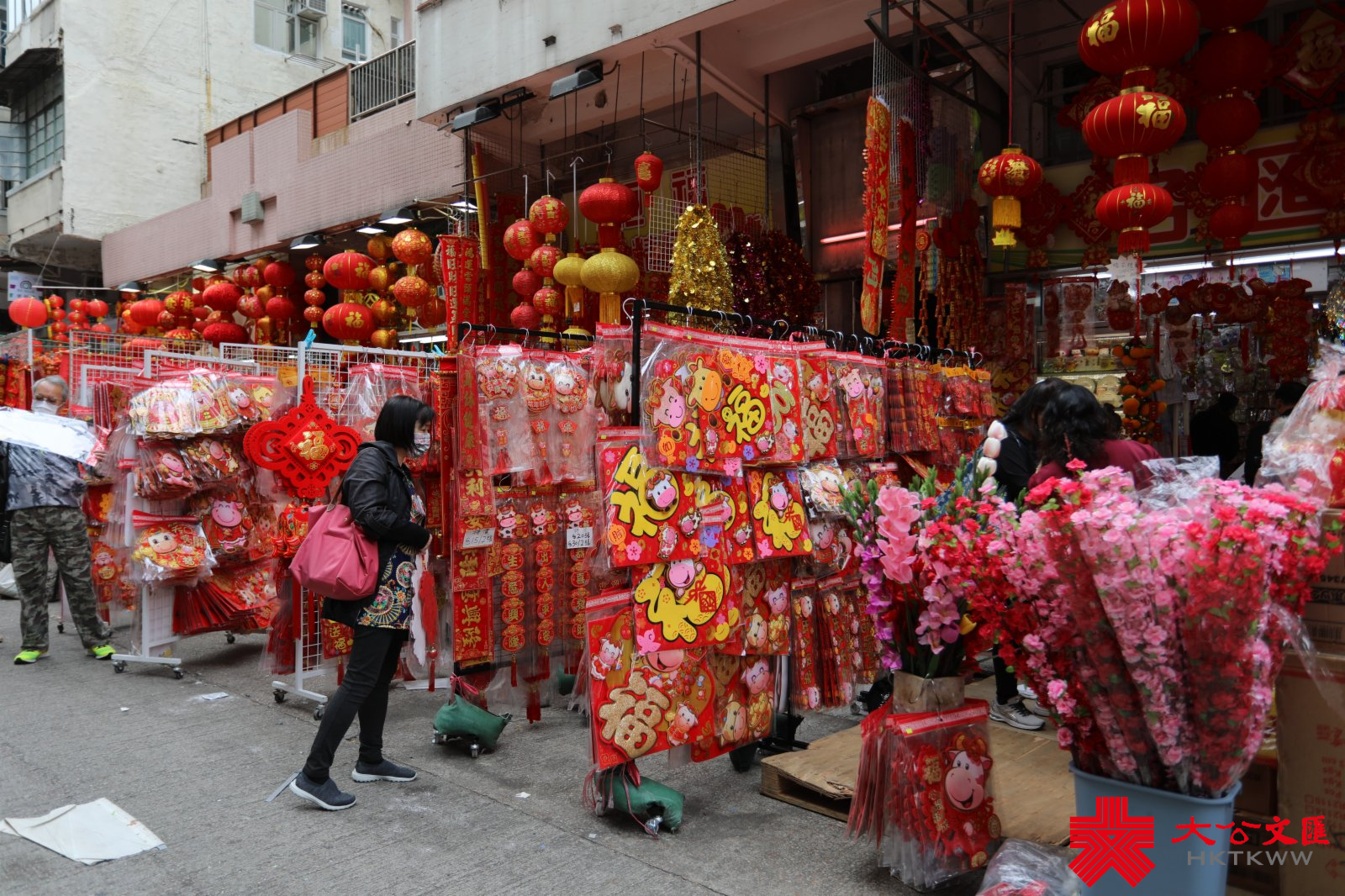 農曆新年將至，有深水埗玩具街之稱的福榮街變身成為「新年街」，不少店鋪在路邊開檔賣牛年賀年公仔、特色揮春，利是封等，大半條街都一片紅噹噹，充滿濃厚節日氣氛。多款賀年飾品唔單止價錢吸引，而且款式仲好齊全，吸引大批市民帶埋一家大細來置辦年貨。（大公文匯全媒體記者 李斯哲攝）