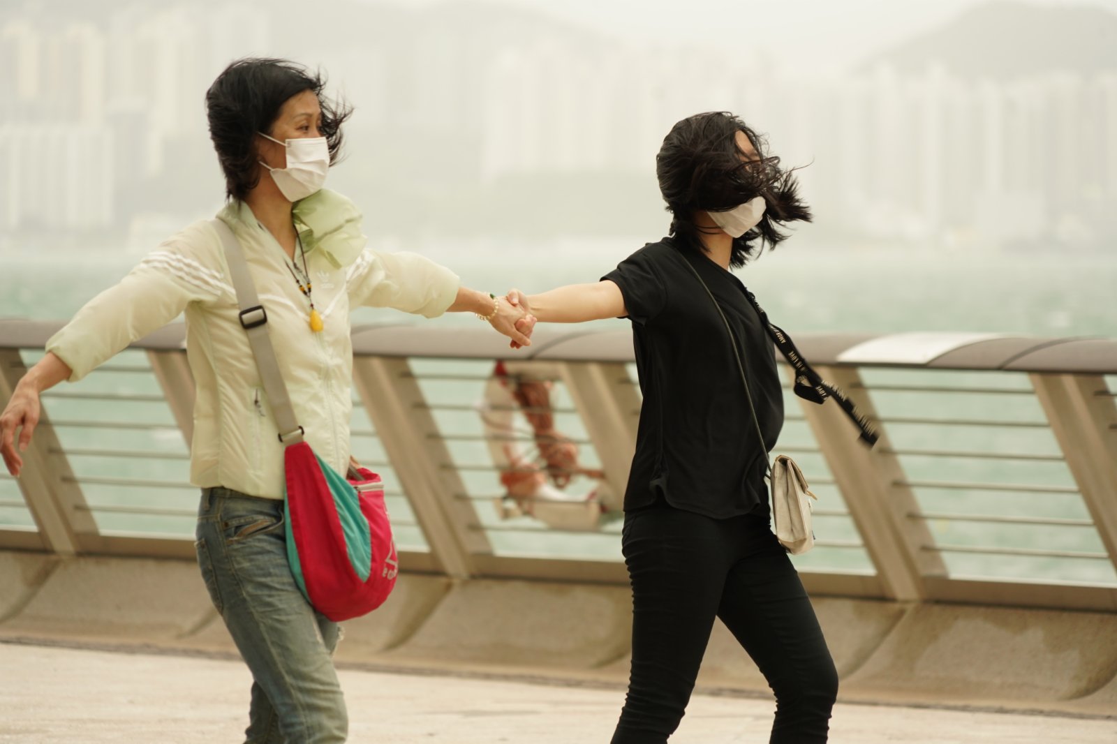 強烈熱帶風暴「圓規」已增強為颱風，天文台昨日（12日）下午5時20分發出八號東北烈風或暴風信號，目前仍然生效。圖為今日（13日）八號風球下，頂風出行的市民。（記者林良堅 攝）