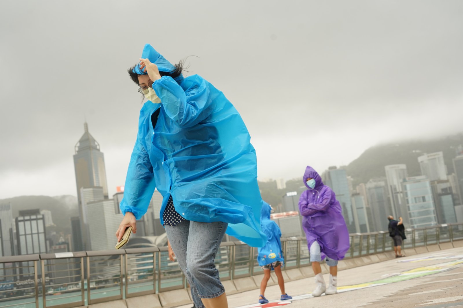 強烈熱帶風暴「圓規」已增強為颱風，天文台昨日（12日）下午5時20分發出八號東北烈風或暴風信號，目前仍然生效。圖為今日（13日）八號風球下，頂風出行的市民。（記者林良堅 攝）