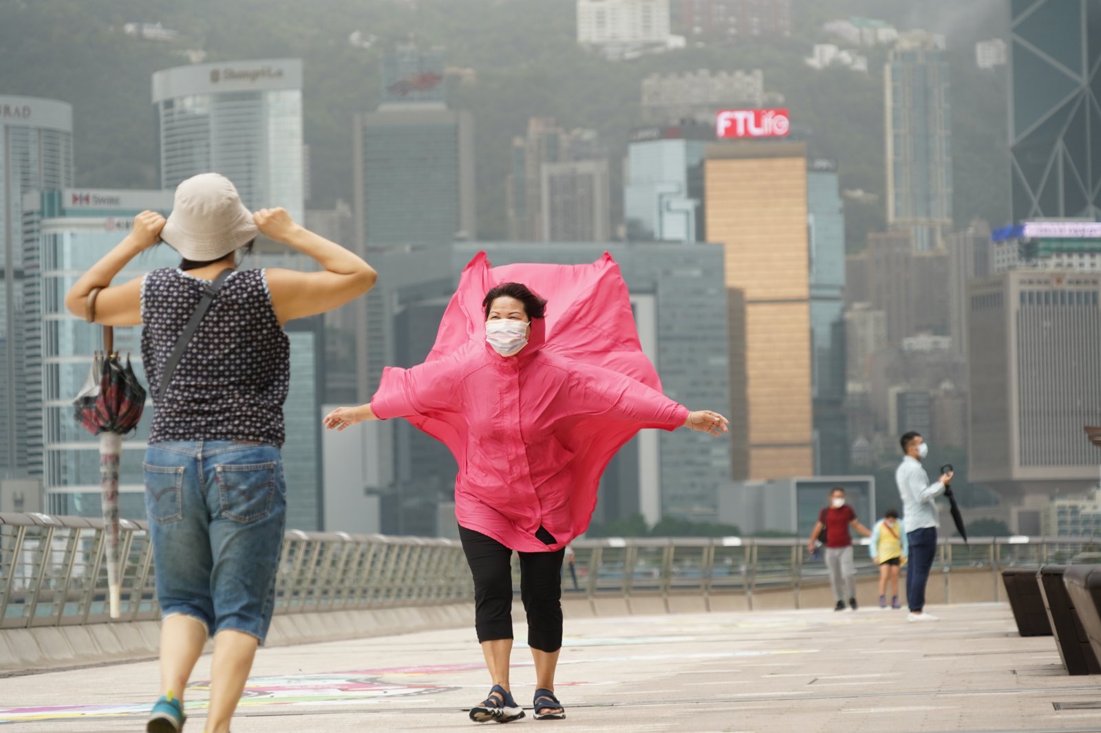 強烈熱帶風暴「圓規」已增強為颱風，天文台昨日（12日）下午5時20分發出八號東北烈風或暴風信號，目前仍然生效。圖為今日（13日）八號風球下，頂風出行的市民。（記者林良堅 攝）