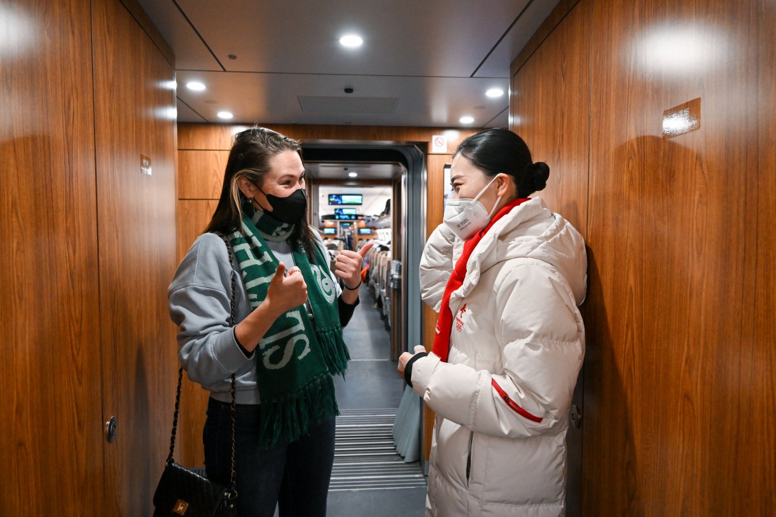 2021年12月30日，在G8811次列車上，吳一凡（右）與一名外國乘客交談（新華社圖片）