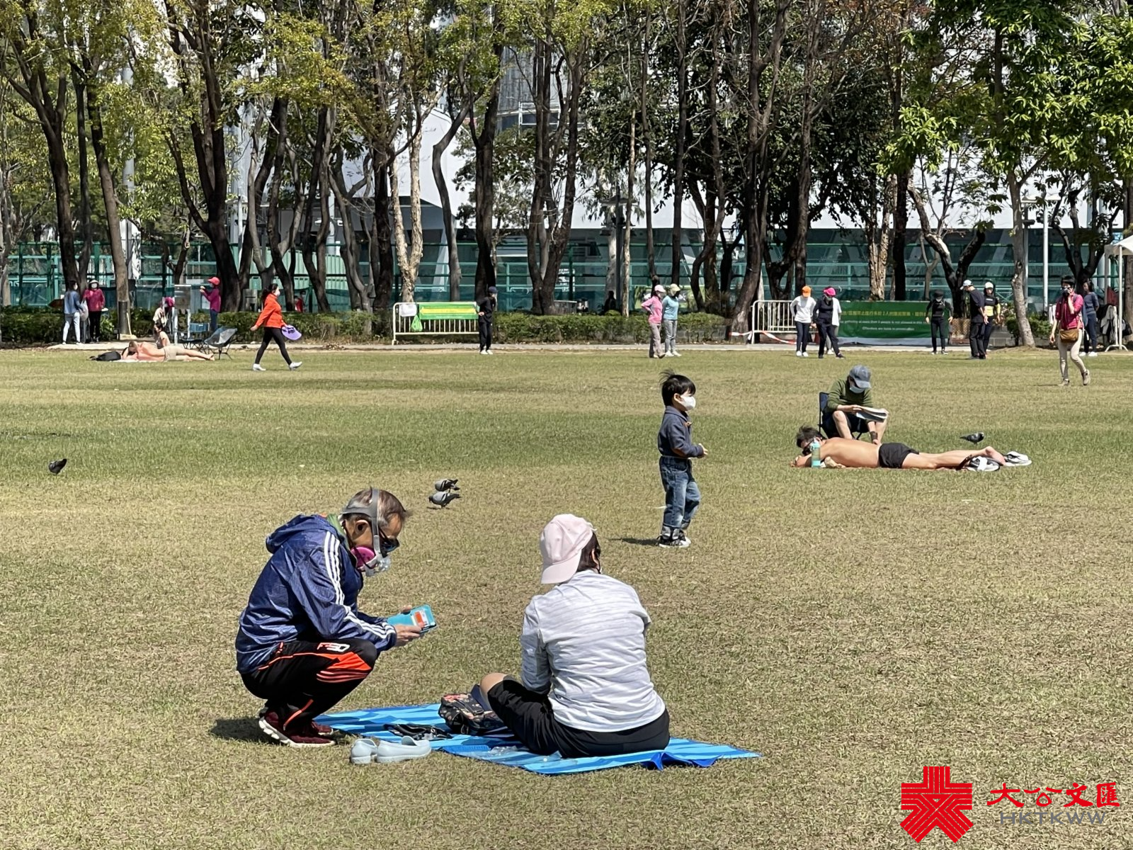 香港第五波疫情持續嚴峻，單日確診個案首次破萬，昨日再多10010宗確診個案，連同初確在內的呈報個案近2.2萬宗。今日（26日）記者走訪維多利亞公園，休閒市民大都遵守限聚令及戴口罩，惟仍有部分外傭超過二人聚集，有康文署人員現場巡查。（大公文匯全媒體記者攝）
