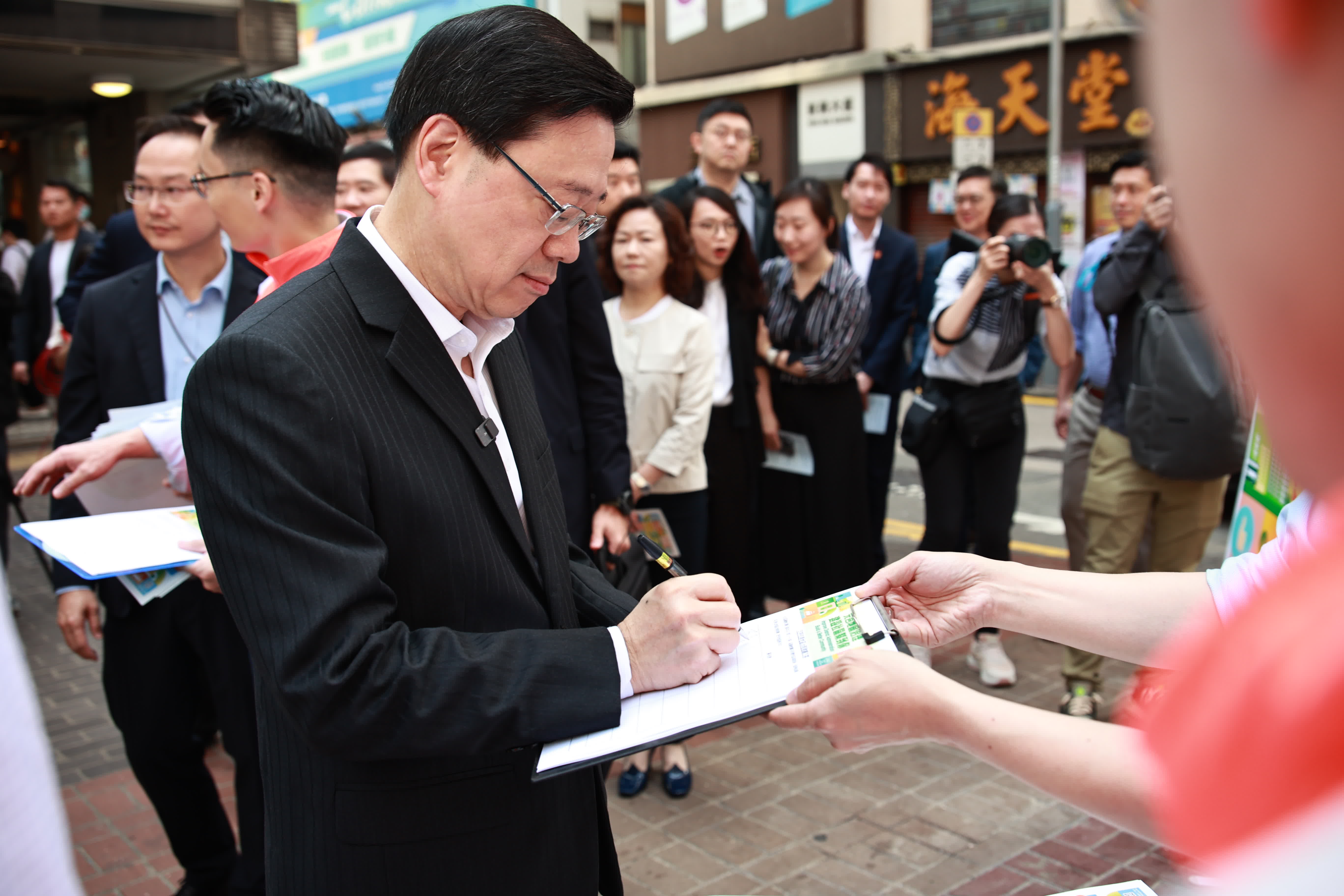 特區政府公布「完善地區治理建議方案」，新一屆區議會議席將由委任、地區委員會界別選舉和地方選區選舉等多種方式產生，並引入資格審查制度。民建聯及工聯會今日（5日）早上在港鐵灣仔站外設置聯合撐「區議會改革」街站，收集市民簽名支持方案。行政長官李家超到場打氣簽名，並與在場的立法會議員等人士宣傳新方案。

多名立法會議員包括民建聯副主席陳克勤、工聯會會長吳秋北、郭偉強、梁熙、陳學峰議員亦在場爭取市民支持方案。（大公文匯全媒體記者攝）