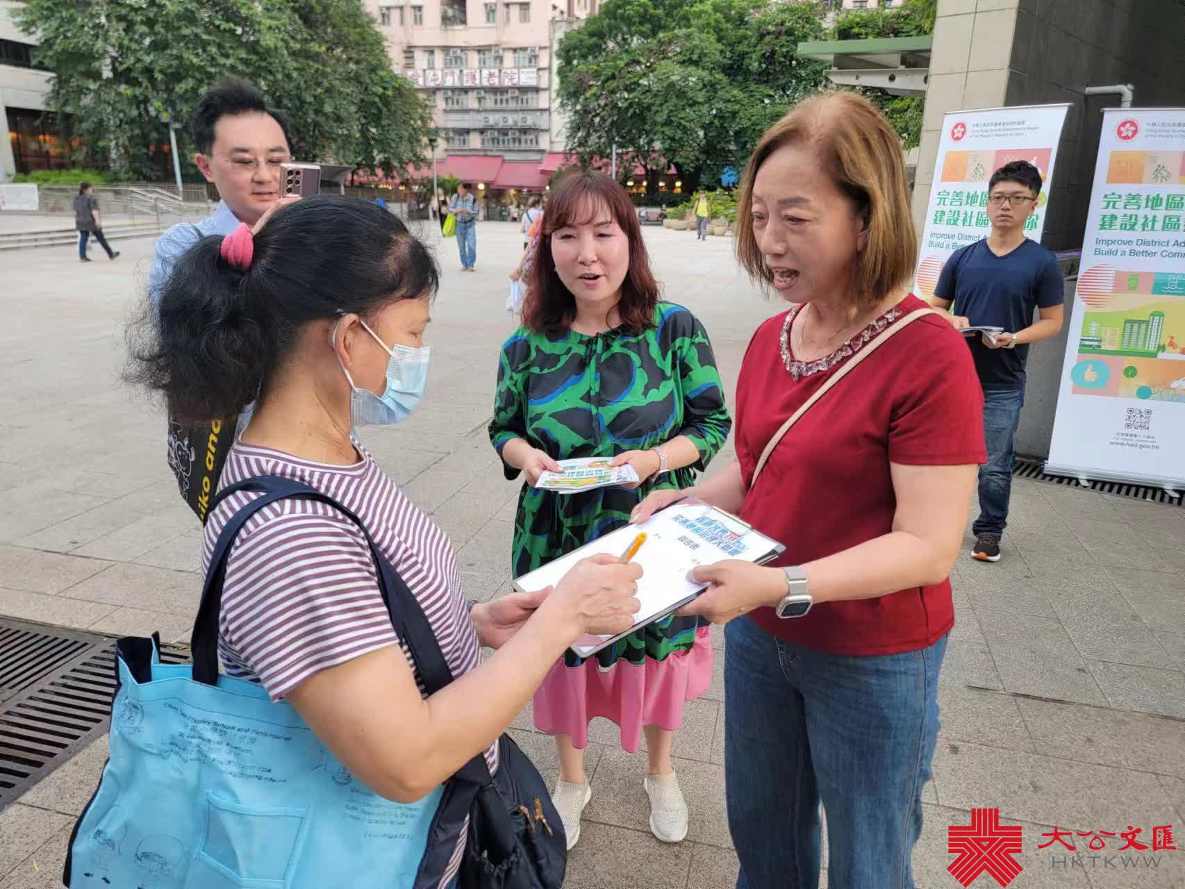 屯門民政事務專員馮雅慧(中)今日下午在屯門仁愛廣場向市民解說完善地區治理建議。(大公文匯全媒體記者馮沛賢攝)
