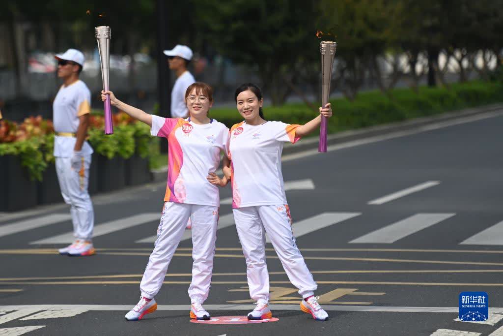 9月14日，火炬手繆雨（左）、張露娜在火炬傳遞中。

當日，杭州亞運會火炬在浙江省台州傳遞。（新華社記者黃宗治攝）
