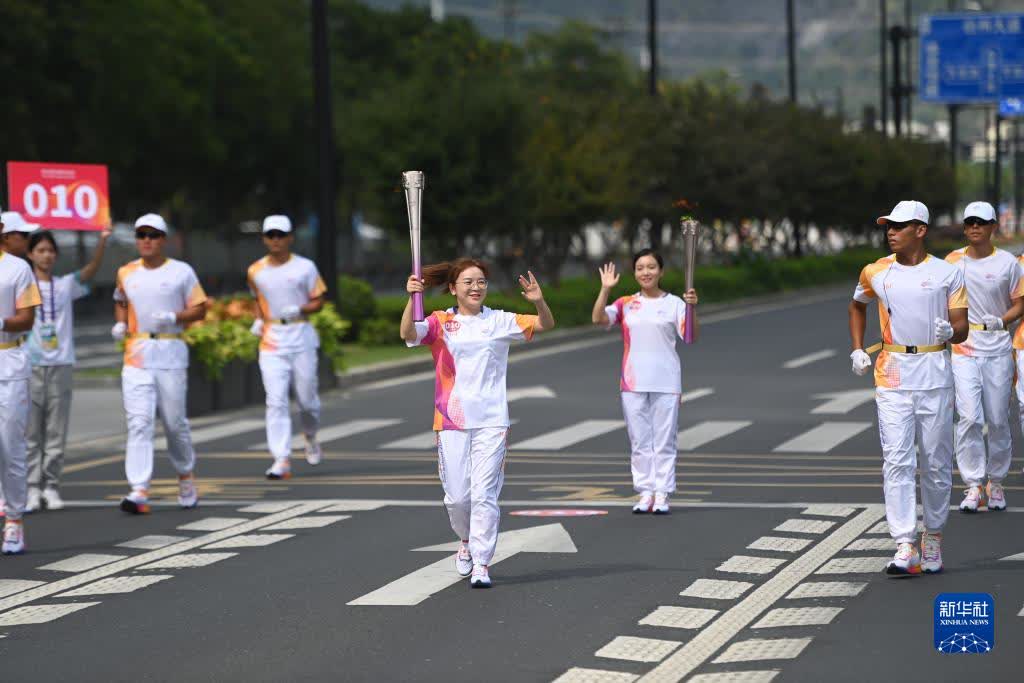 9月14日，火炬手繆雨（中）在火炬傳遞中。

當日，杭州亞運會火炬在浙江省台州傳遞。（新華社記者黃宗治攝）