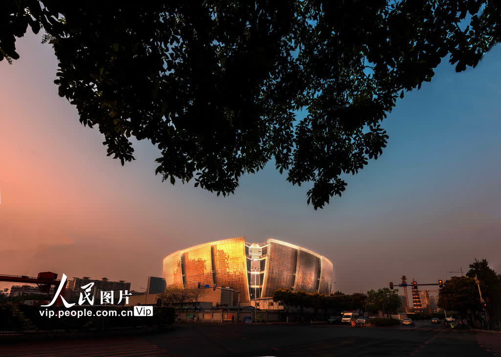 木棉是廣州市花，又稱「英雄花」。廣州藝術博物院（廣州美術館）新館主體建築外形猶如一朵「盛放的英雄花」。圖為2023年10月31日，「木棉」在朝霞映照下光彩奪目。（穆亦攝）