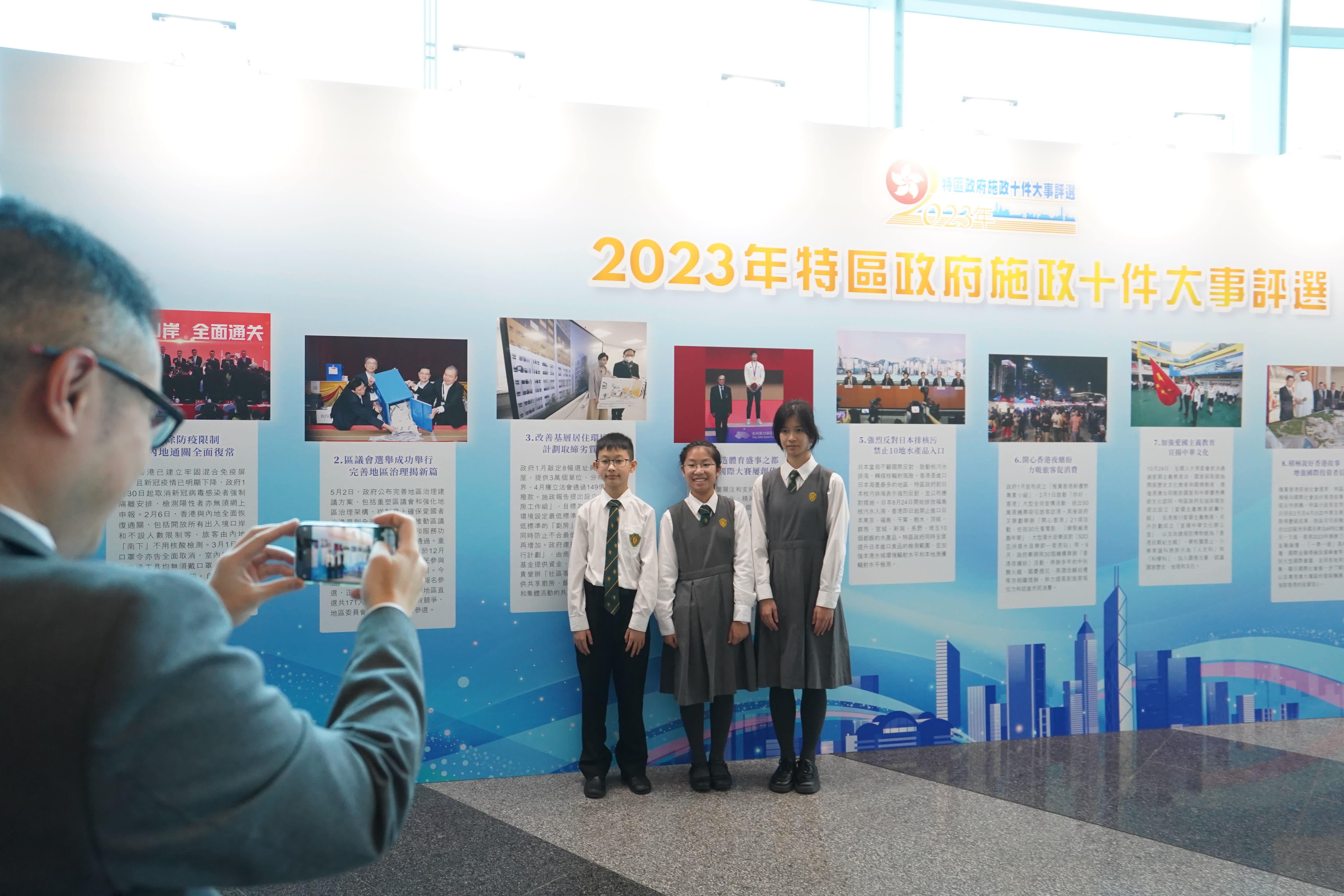 同學們饒有情趣地在背景板前合影留念。