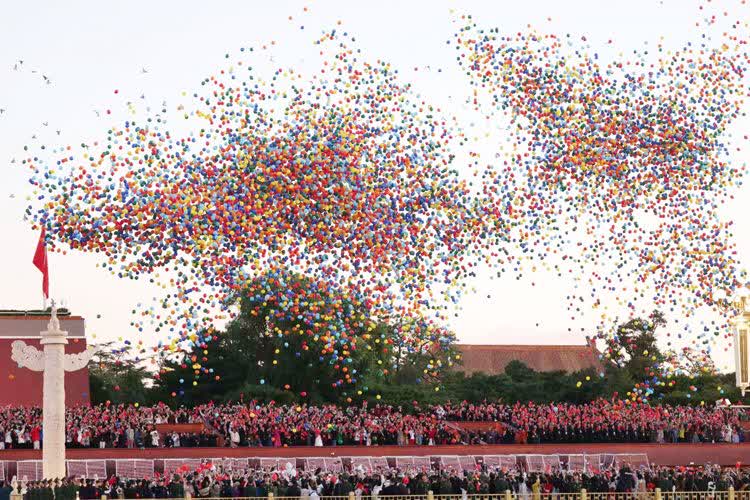 彩色氣球騰空而起，人們揮舞手中的國旗，祝福祖國75周年華誕!（新京報）