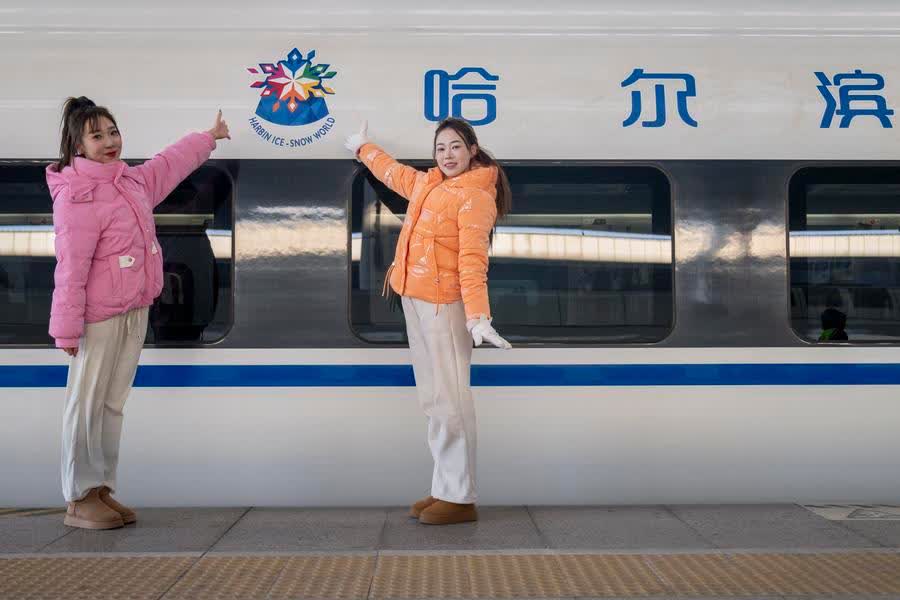 Performers pose for a photo in front of the bullet train No G1276, the first themed high-speed train of the Harbin Ice-Snow World, at Harbin West Station in Harbin, Northeast China's Heilongjiang province, Jan 4, 2026. [Photo/Xinhua]