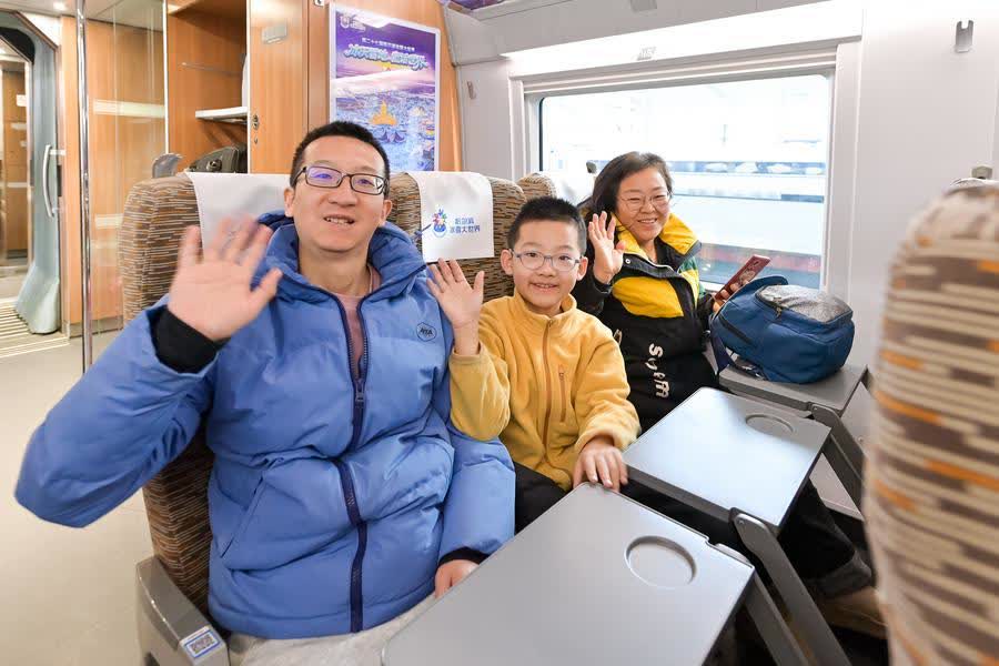 Passengers pose for a group photo on the bullet train No G1276, the first themed high-speed train of the Harbin Ice-Snow World, Jan 4, 2026. [Photo/Xinhua]