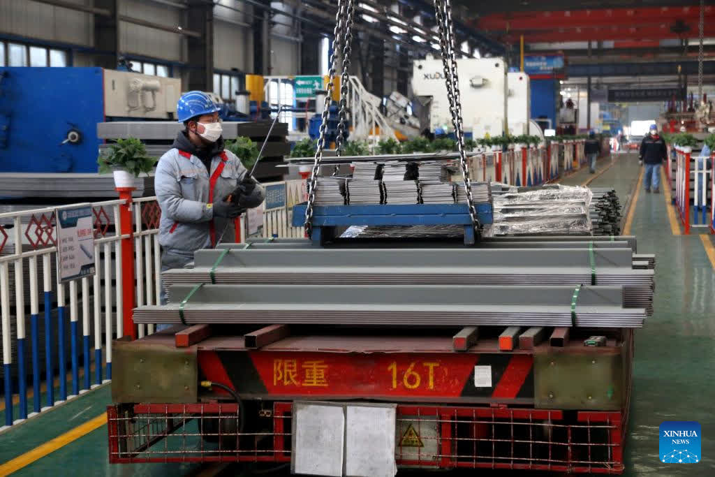 A worker cranes materials for making export containers at a company in an economic and technological development zone in Lianyungang, east China's Jiangsu Province, Jan. 29, 2026. Enterprises across the country are going full steam ahead in production at the end of January, striving for a strong start in the first month of a new year. (Photo by Wang Chun/Xinhua)