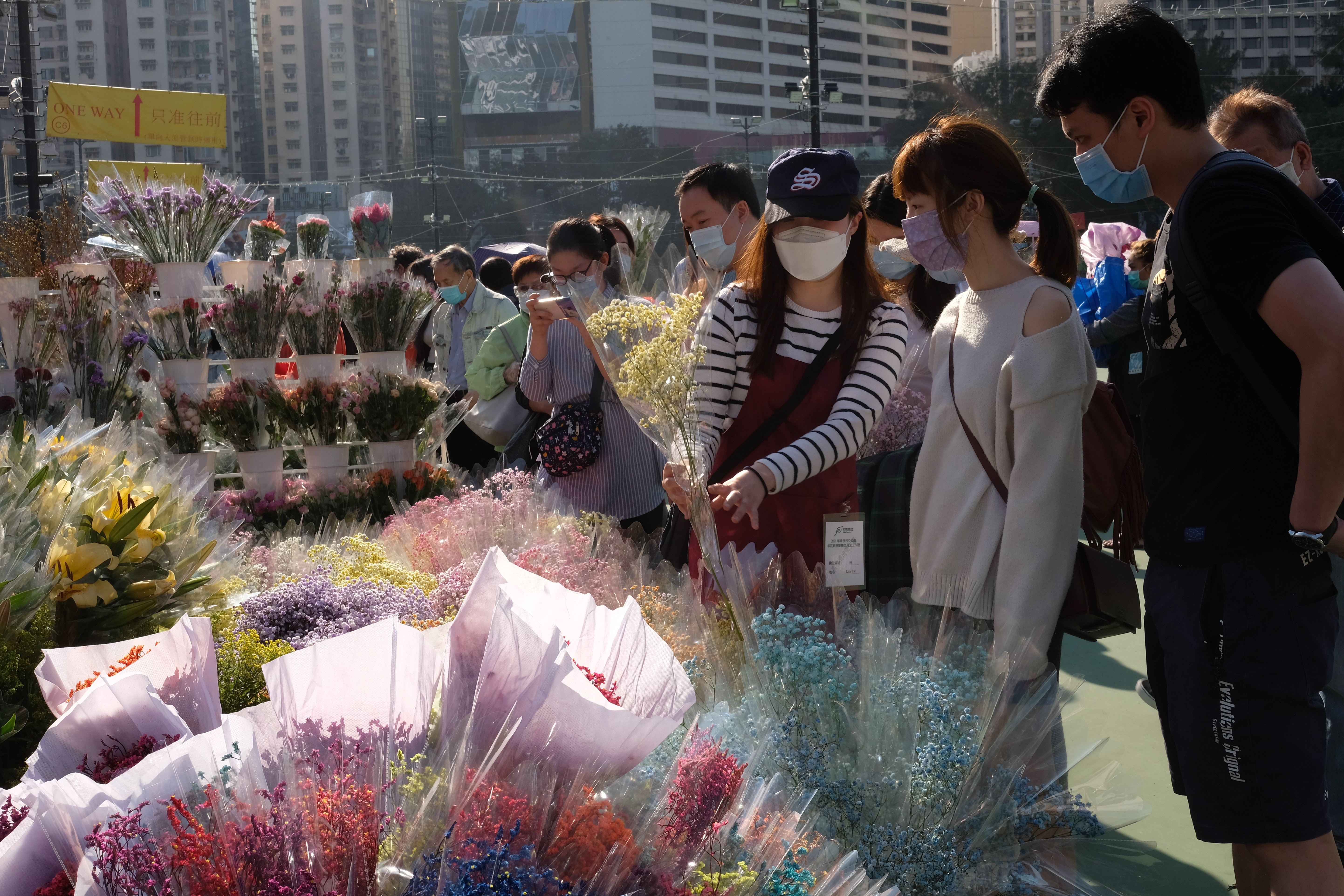 全港15個年宵花市今日（6日）開鑼，將持續至下周四的大年三十。花市出入口設紅、黃、綠燈人流管制系統。每名進內人士須進行體溫檢測，現場設有紅外線傳感器以計算場內人數。圖為維多利亞公園花市，市民井然採購年花。（大公文匯全媒體記者麥鈞傑攝）