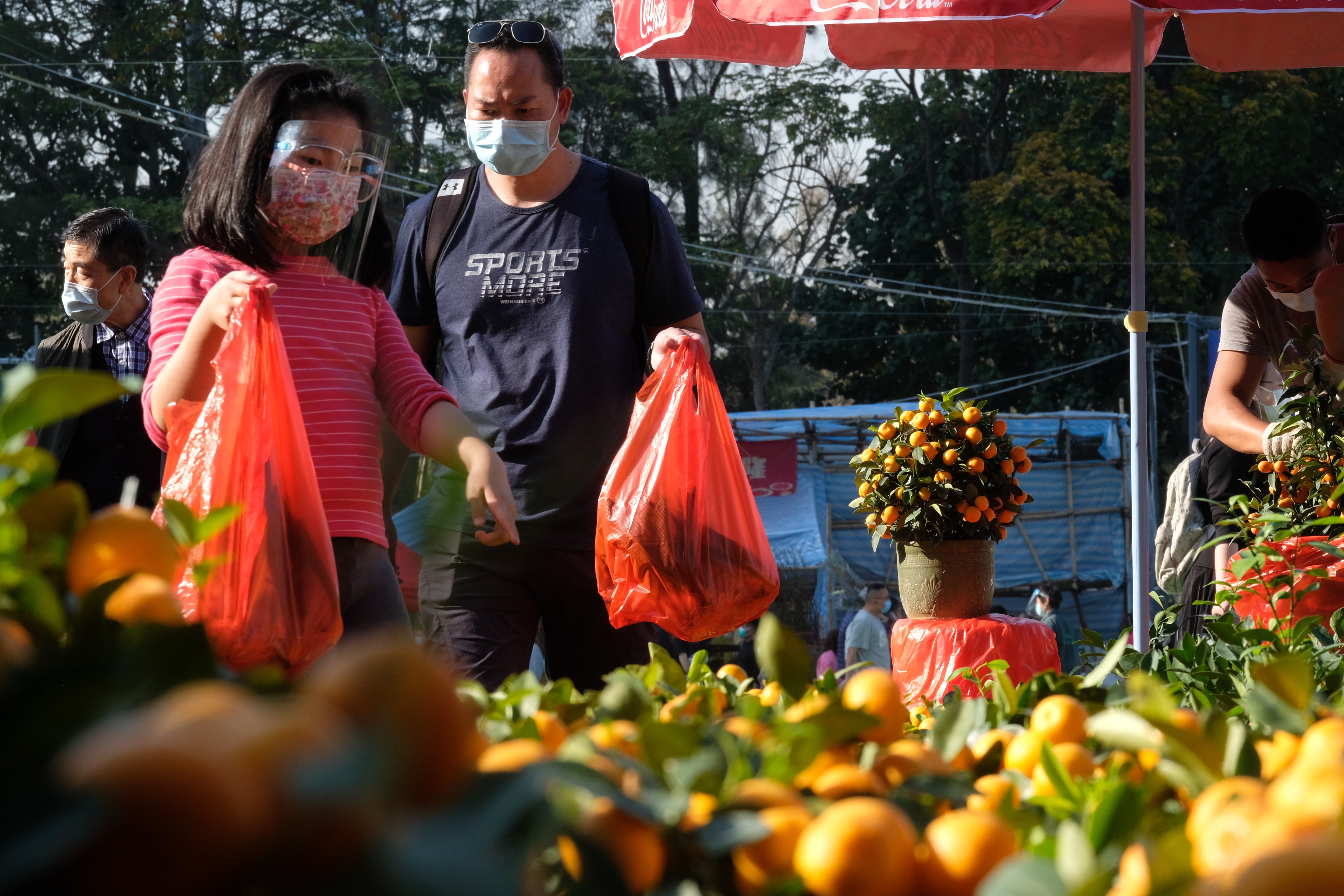 全港15個年宵花市今日（6日）開鑼，將持續至下周四的大年三十。花市出入口設紅、黃、綠燈人流管制系統。每名進內人士須進行體溫檢測，現場設有紅外線傳感器以計算場內人數。圖為維多利亞公園花市，市民井然採購年花。（大公文匯全媒體記者麥鈞傑攝）