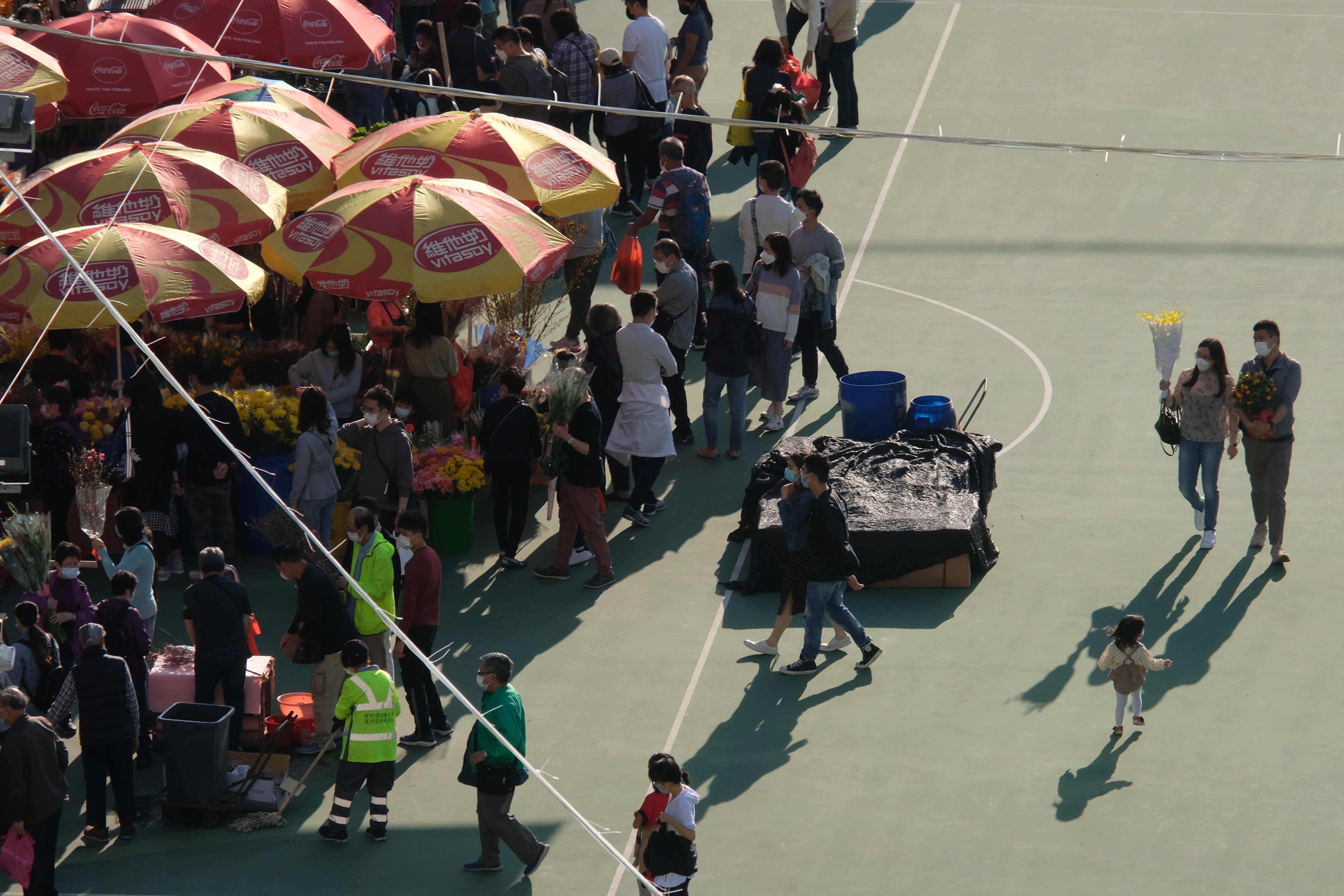 全港15個年宵花市今日（6日）開鑼，將持續至下周四的大年三十。花市出入口設紅、黃、綠燈人流管制系統。每名進內人士須進行體溫檢測，現場設有紅外線傳感器以計算場內人數。圖為維多利亞公園花市，市民井然採購年花。（大公文匯全媒體記者麥鈞傑攝）