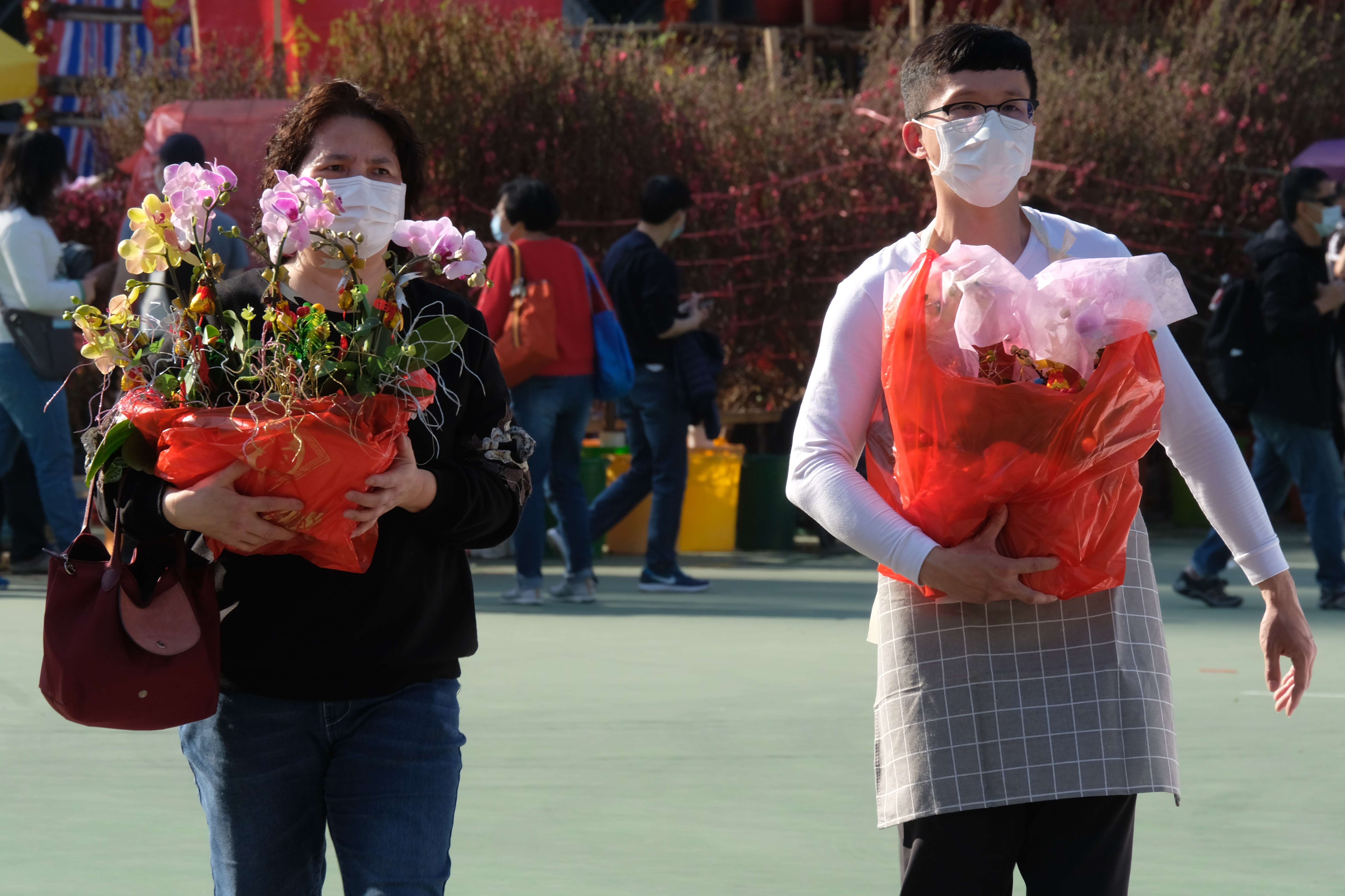 全港15個年宵花市今日（6日）開鑼，將持續至下周四的大年三十。花市出入口設紅、黃、綠燈人流管制系統。每名進內人士須進行體溫檢測，現場設有紅外線傳感器以計算場內人數。圖為維多利亞公園花市，市民井然採購年花。（大公文匯全媒體記者麥鈞傑攝）