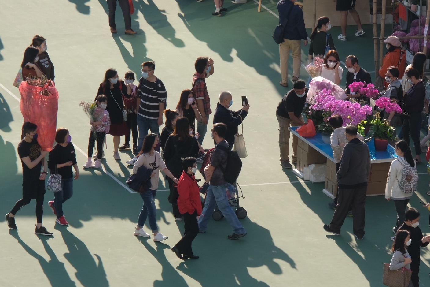 全港15個年宵花市今日（6日）開鑼，將持續至下周四的大年三十。花市出入口設紅、黃、綠燈人流管制系統。每名進內人士須進行體溫檢測，現場設有紅外線傳感器以計算場內人數。圖為維多利亞公園花市，市民井然採購年花。（大公文匯全媒體記者麥鈞傑攝）