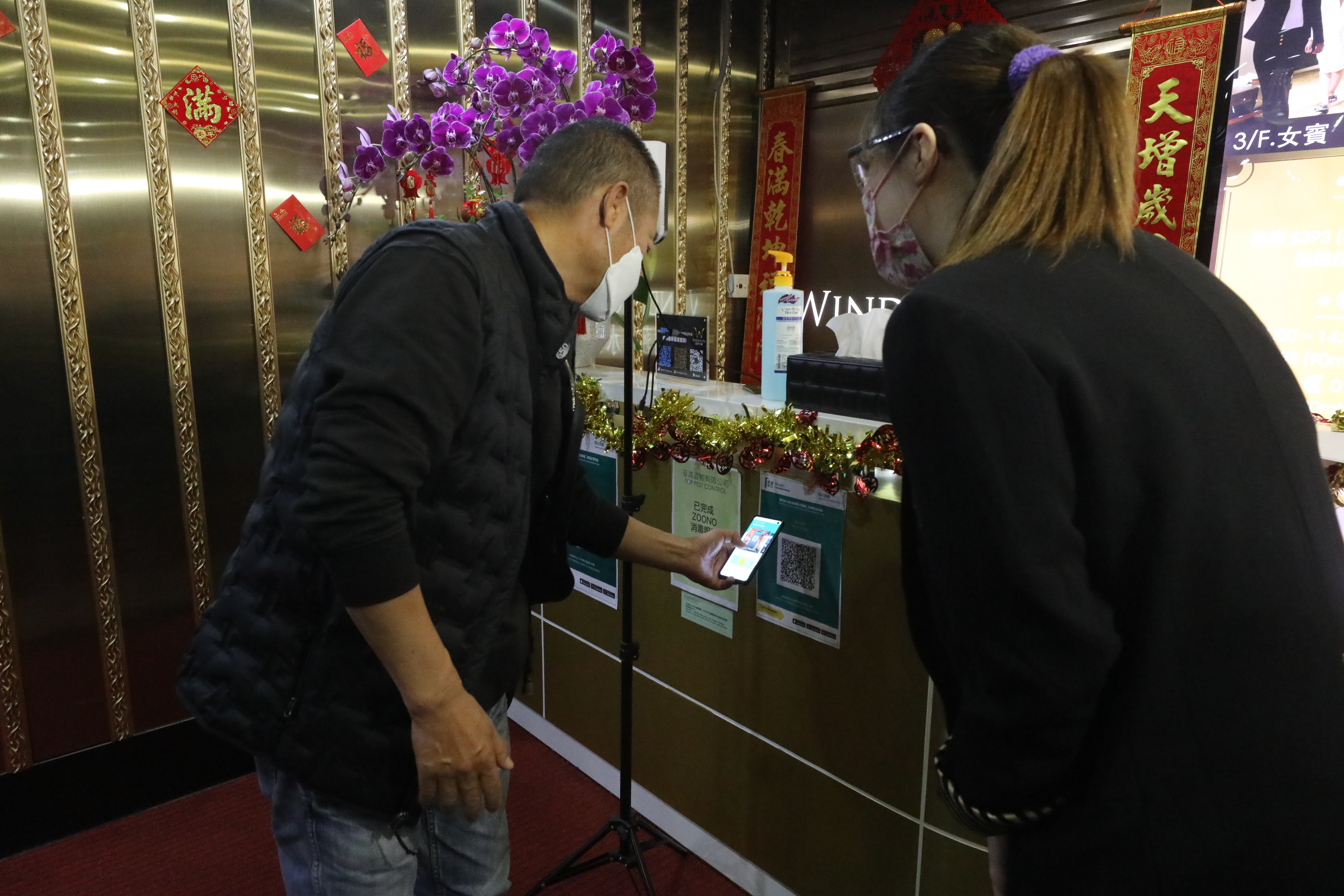 政府今日（18日）起放寬各項防疫措施，包括晚市堂食可延至晚上10時、每枱可坐4人；而限聚令亦可放寬至4人。多個處所都可以重開，包括體育場所、博物館、主題公園、遊樂場地等。圖為社交距離措施放寬後，Spa會所重新開業，市民掃描「安心出行」應用程式後，才可以進入。（香港文匯報 記者 
 萬霜靈 攝）