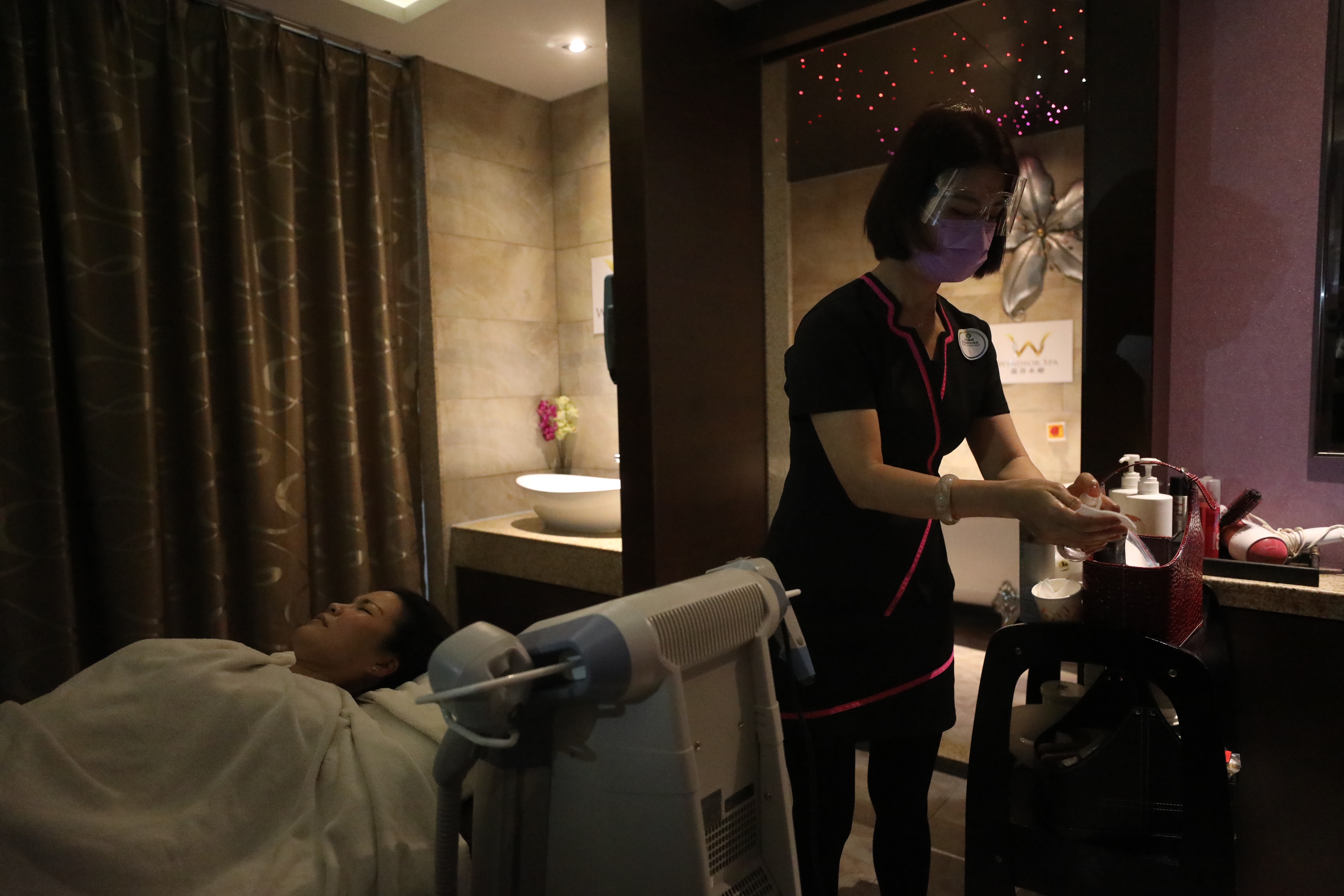 政府今日（18日）起放寬各項防疫措施，包括晚市堂食可延至晚上10時、每枱可坐4人；而限聚令亦可放寬至4人。多個處所都可以重開，包括體育場所、博物館、主題公園、遊樂場地等。圖為社交距離措施放寬後，Spa會所重新開業，市民掃描「安心出行」應用程式後，才可以進入。（香港文匯報 記者 
 萬霜靈 攝）