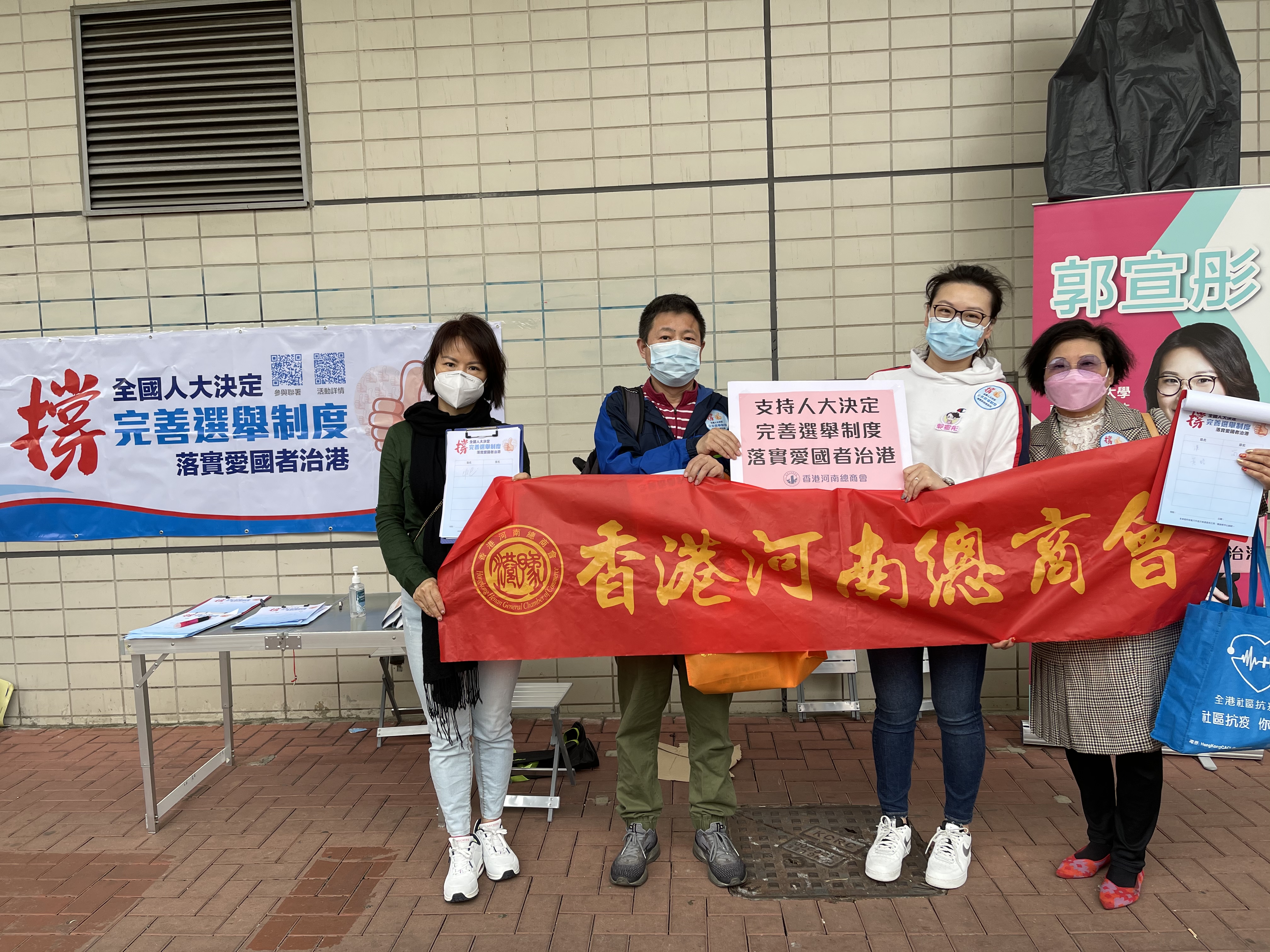 香港河南總商會理事長高波，香港河南總商會青年委員會主席、沙田圍社區窩心服務隊隊長郭宣彤一同在沙田圍地鐵站宣傳人大完善香港選舉制度的決定，呼籲市民簽名支持。（受訪者供圖）