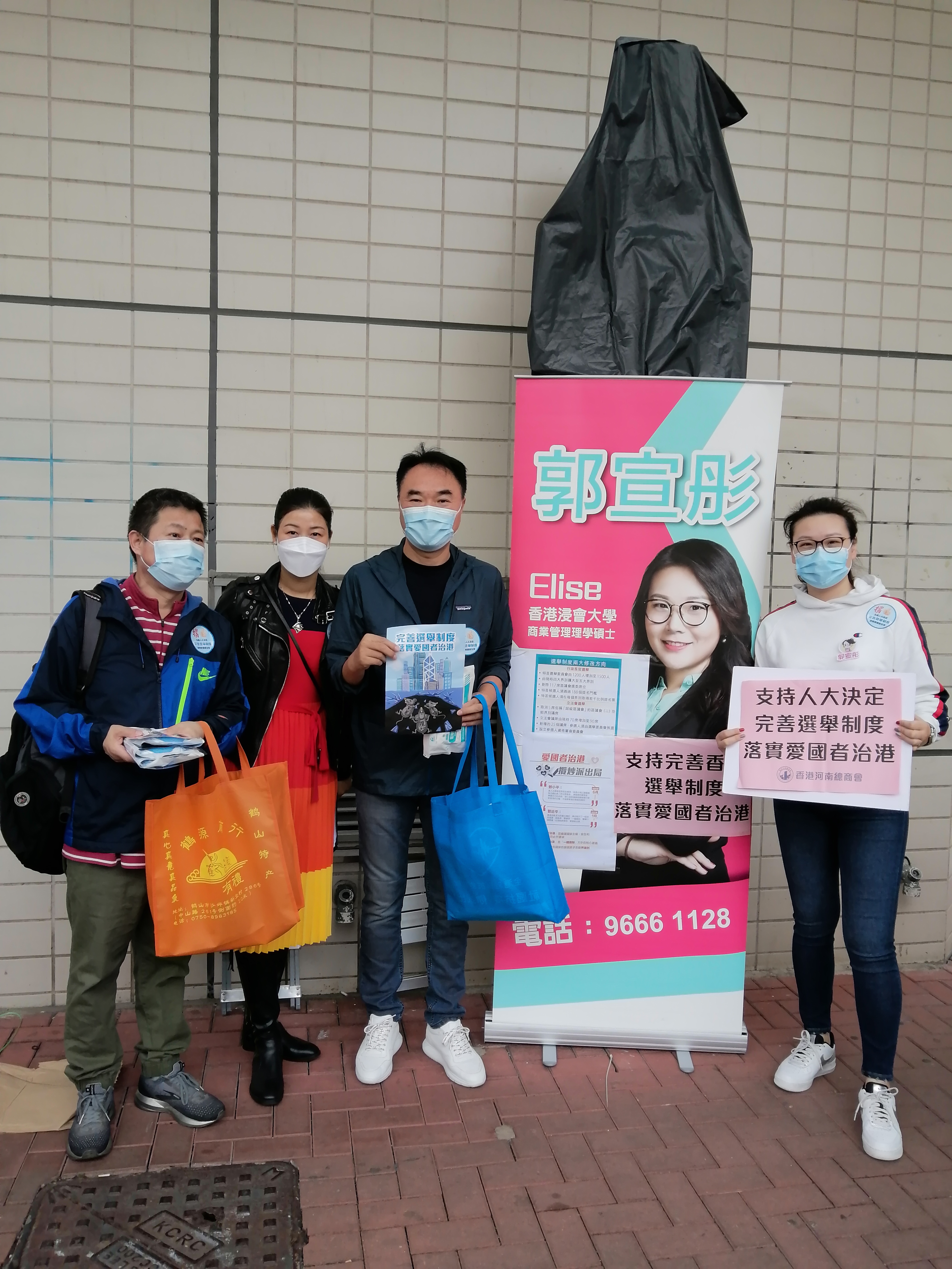 香港河南總商會理事長高波，香港河南總商會青年委員會主席、沙田圍社區窩心服務隊隊長郭宣彤一同在沙田圍地鐵站宣傳人大完善香港選舉制度的決定，呼籲市民簽名支持。（受訪者供圖）