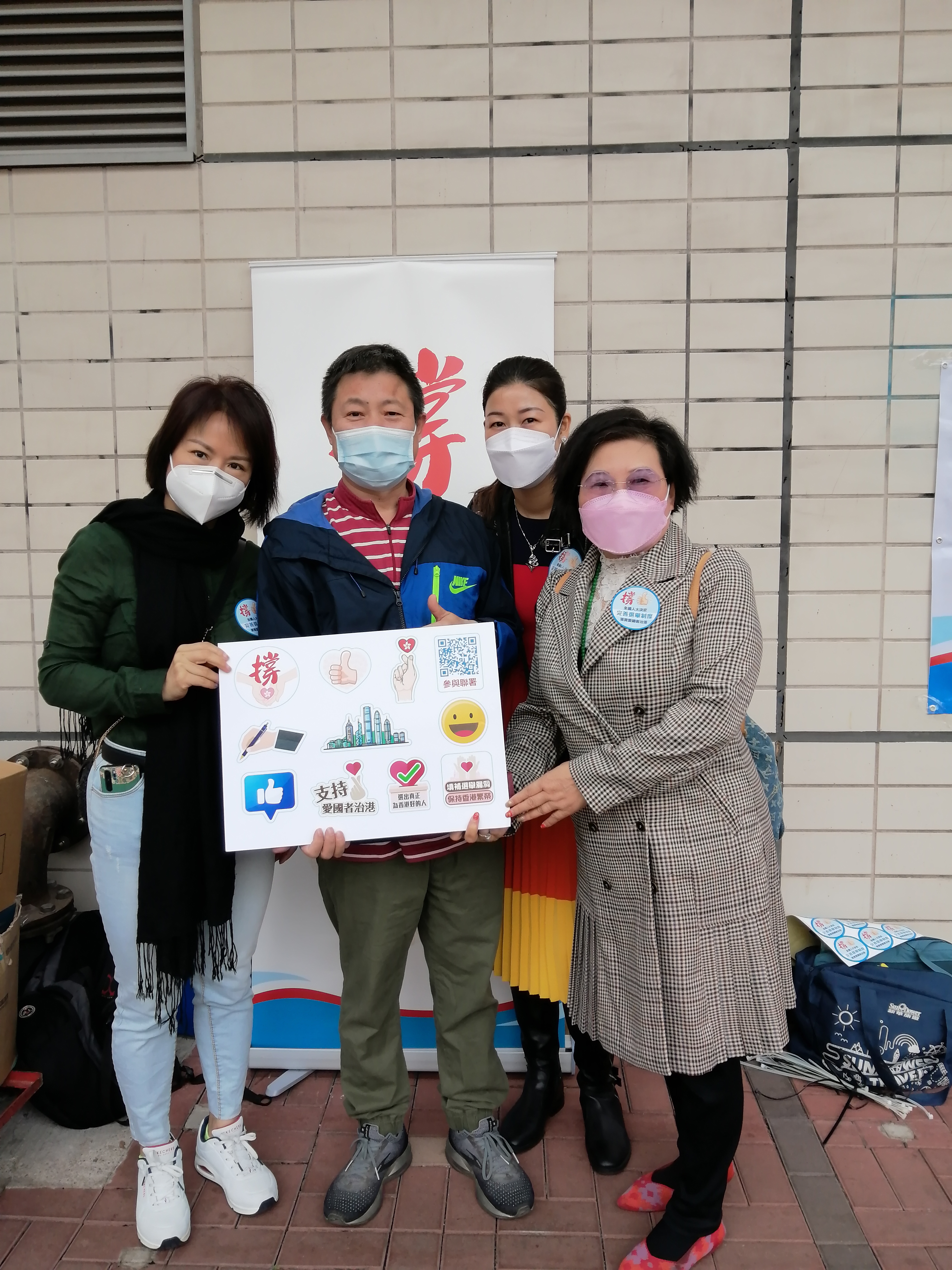 香港河南總商會理事長高波，香港河南總商會青年委員會主席、沙田圍社區窩心服務隊隊長郭宣彤一同在沙田圍地鐵站宣傳人大完善香港選舉制度的決定，呼籲市民簽名支持。（受訪者供圖）