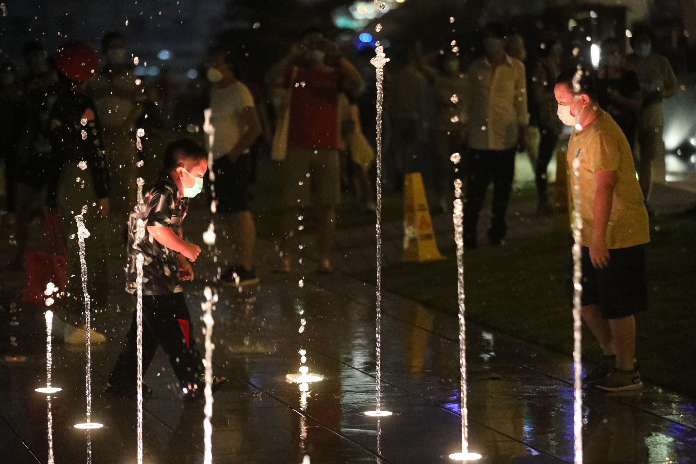 許多小童興奮與噴泉互動，穿梭水柱間嬉戲。（香港文匯報記者 萬靈霜 攝）