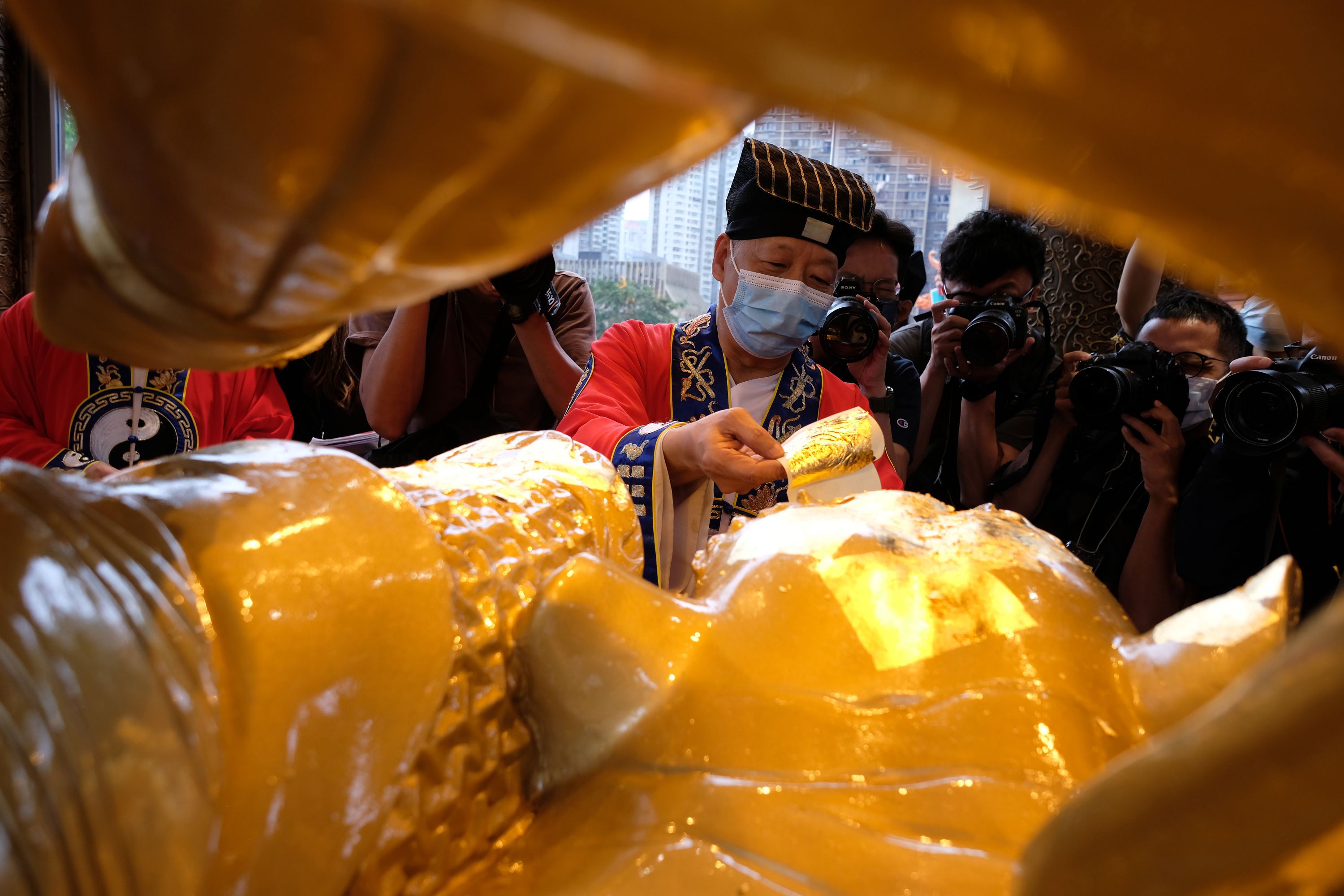 貼好金箔後，還要向神像抱拳作揖，才算禮成。（大公文匯全媒體記者 麥鈞傑 攝）