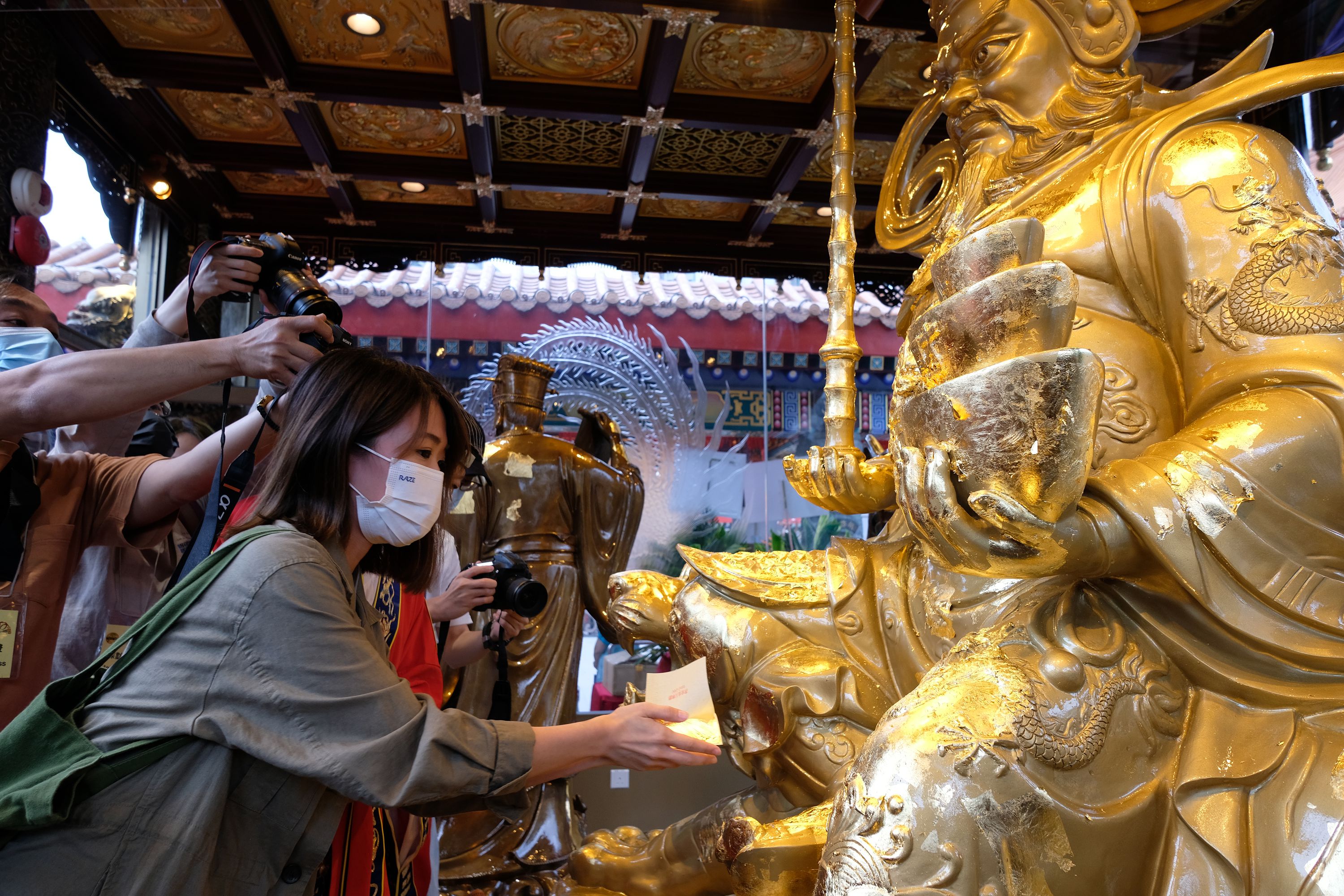 之後，將金箔貼在殿內神像上，注意不可貼在神像頭部。（大公文匯全媒體記者 麥鈞傑 攝）