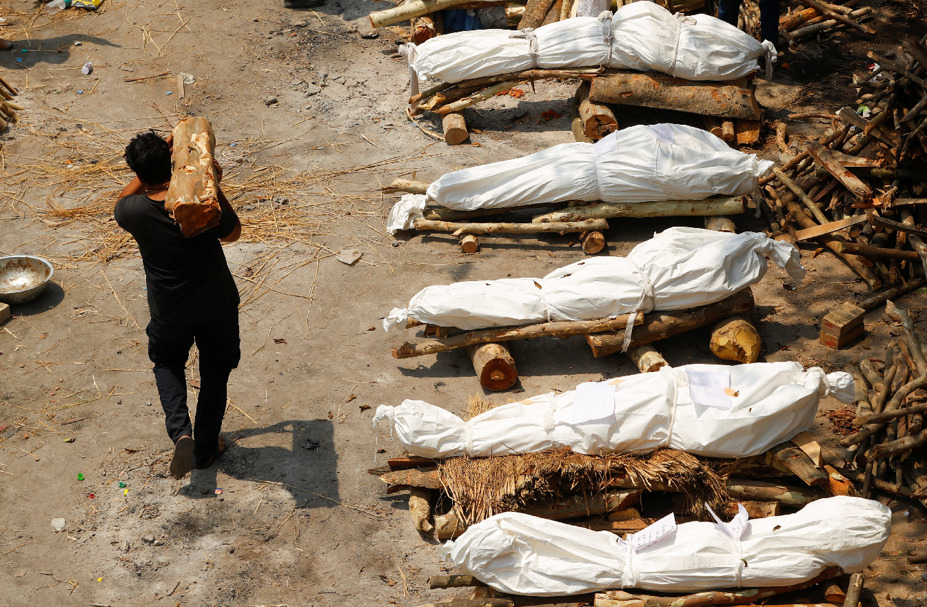 印度疫情瀕臨失控。由於醫療及殯葬場所匱乏，大批確診死亡者的屍體來不及處理，親人只能忍痛在露天場所生火焚燒火化。（圖：路透社）