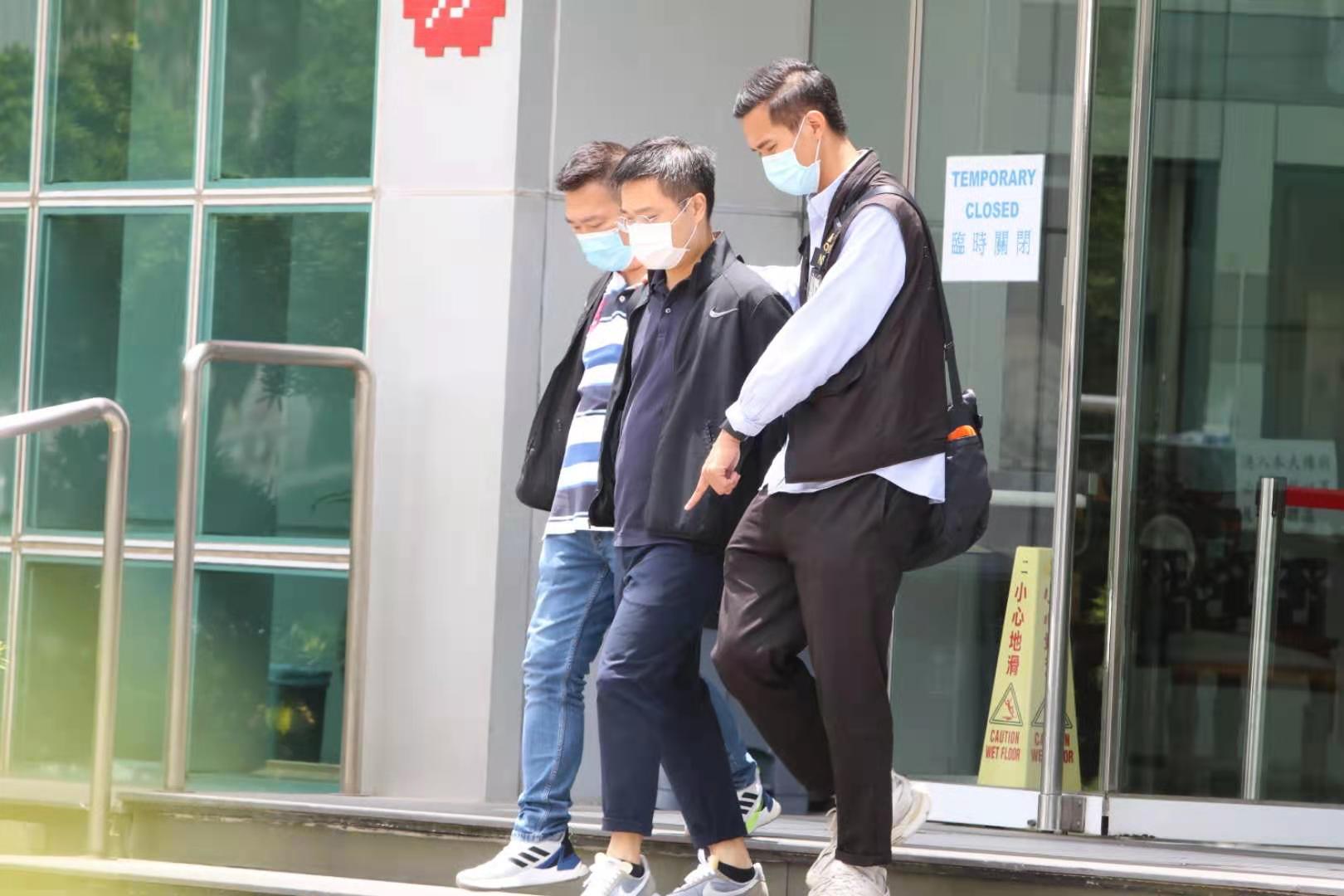 《蘋果日報》總編輯羅偉光在警員押送下離開大樓。（香港文匯報記者 攝）