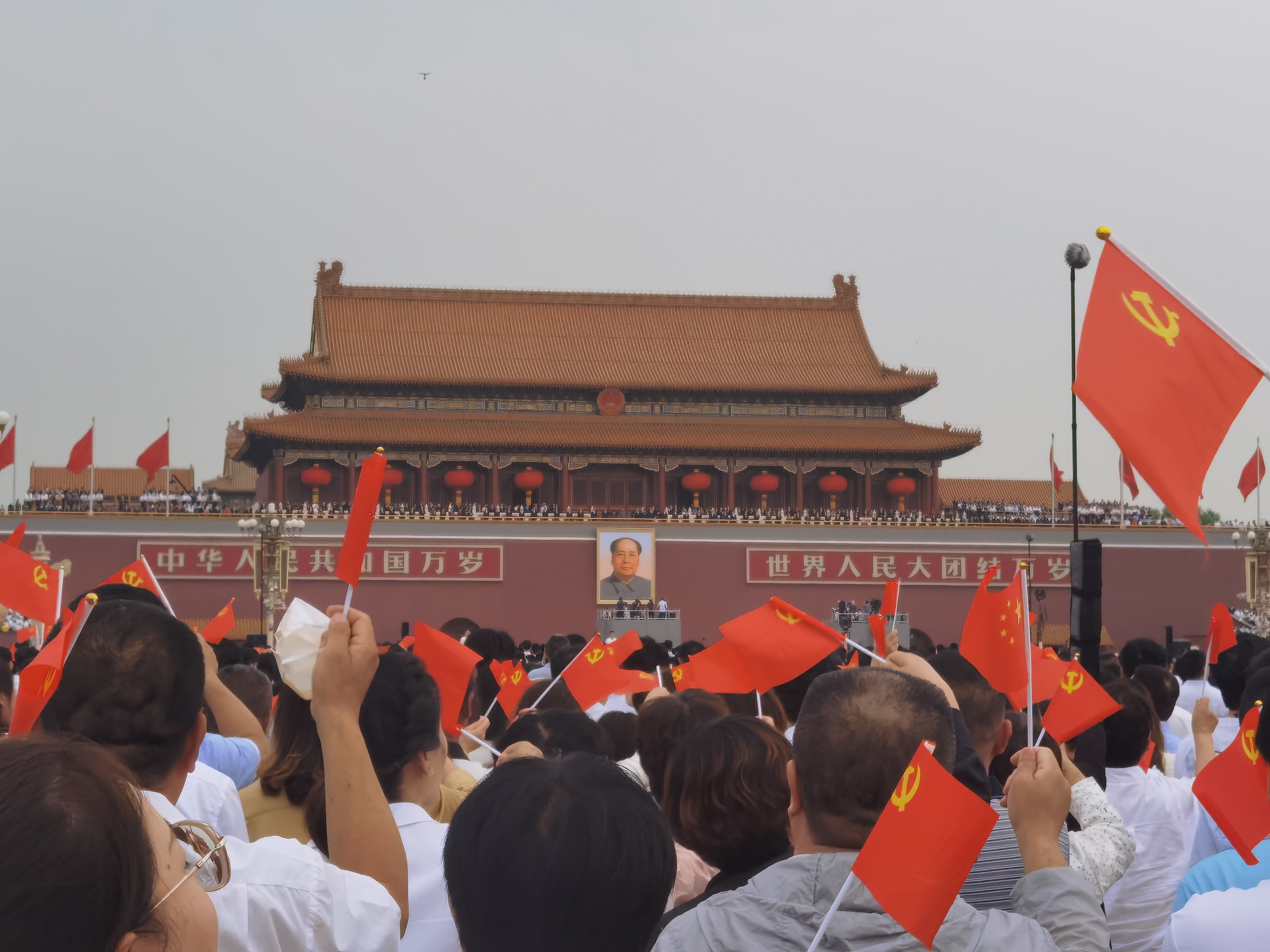 觀禮嘉賓面對天安門城樓揮舞着黨旗（ 大公文匯全媒體記者朱燁攝 朱燁攝 ）