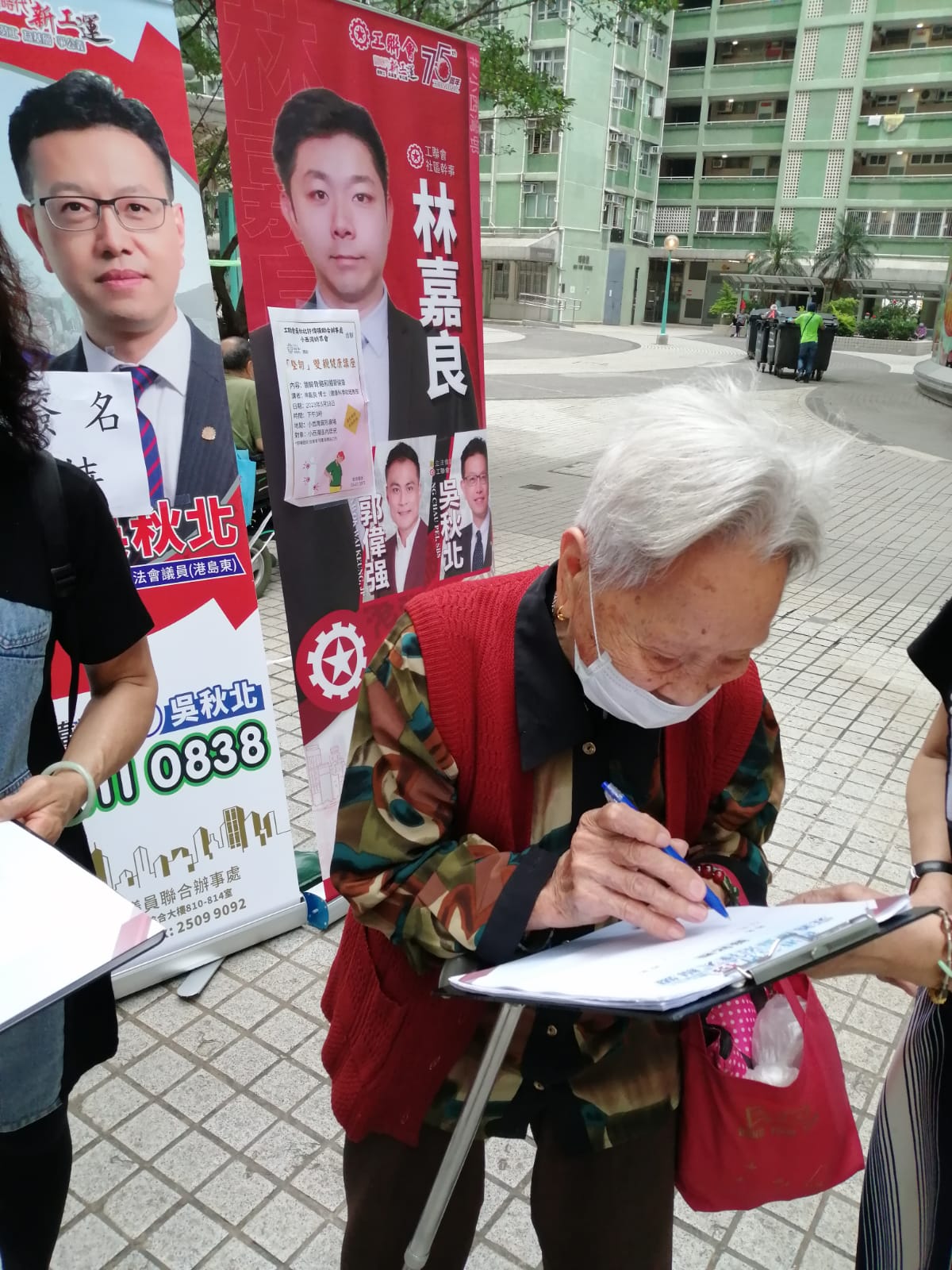 社區幹事林嘉良與幾位義工在港島的屋邨收集簽名。(受訪者提供)