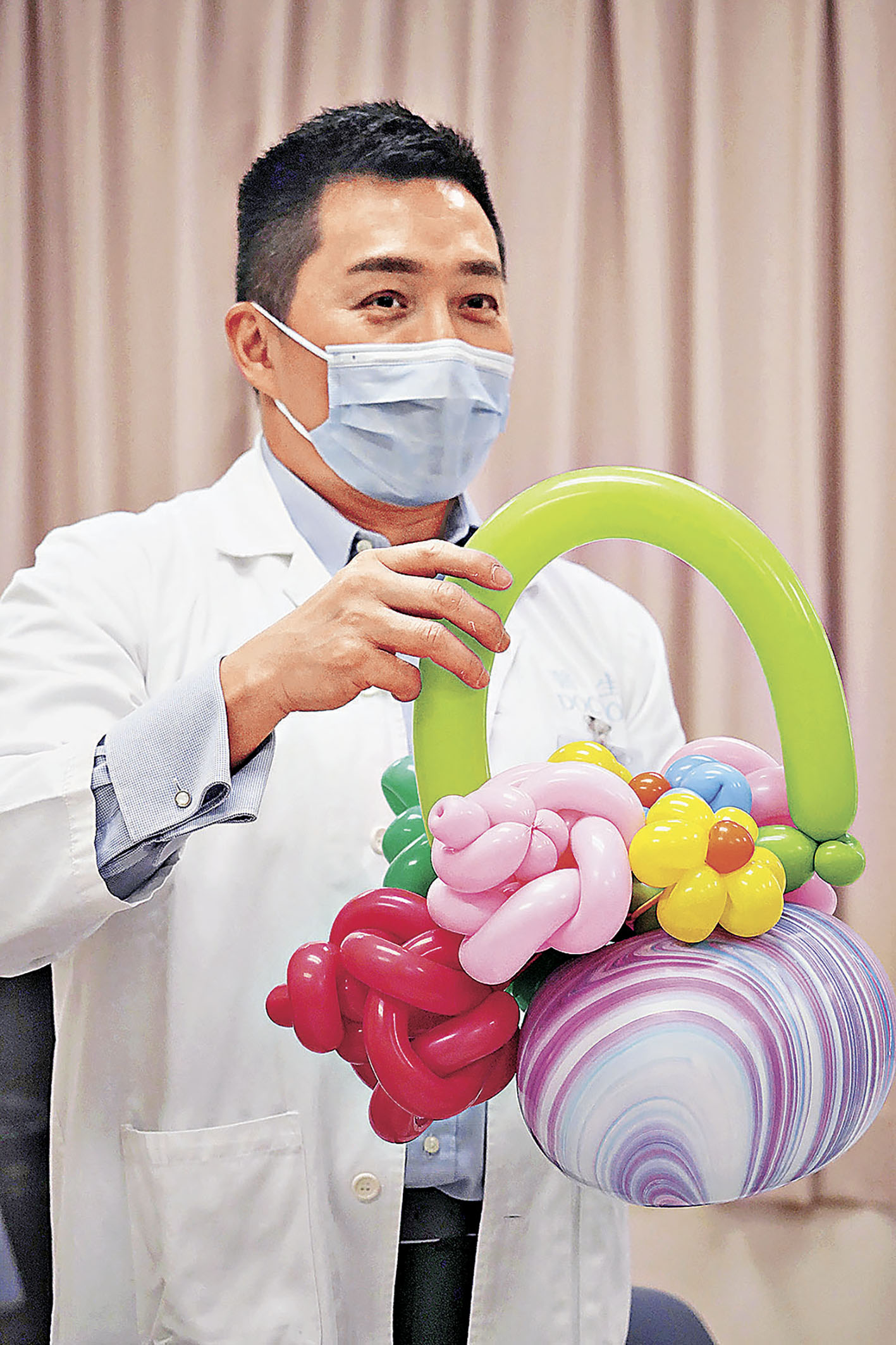 ■陳諾文醫生展示親手製作的氣球花籃。 新華社